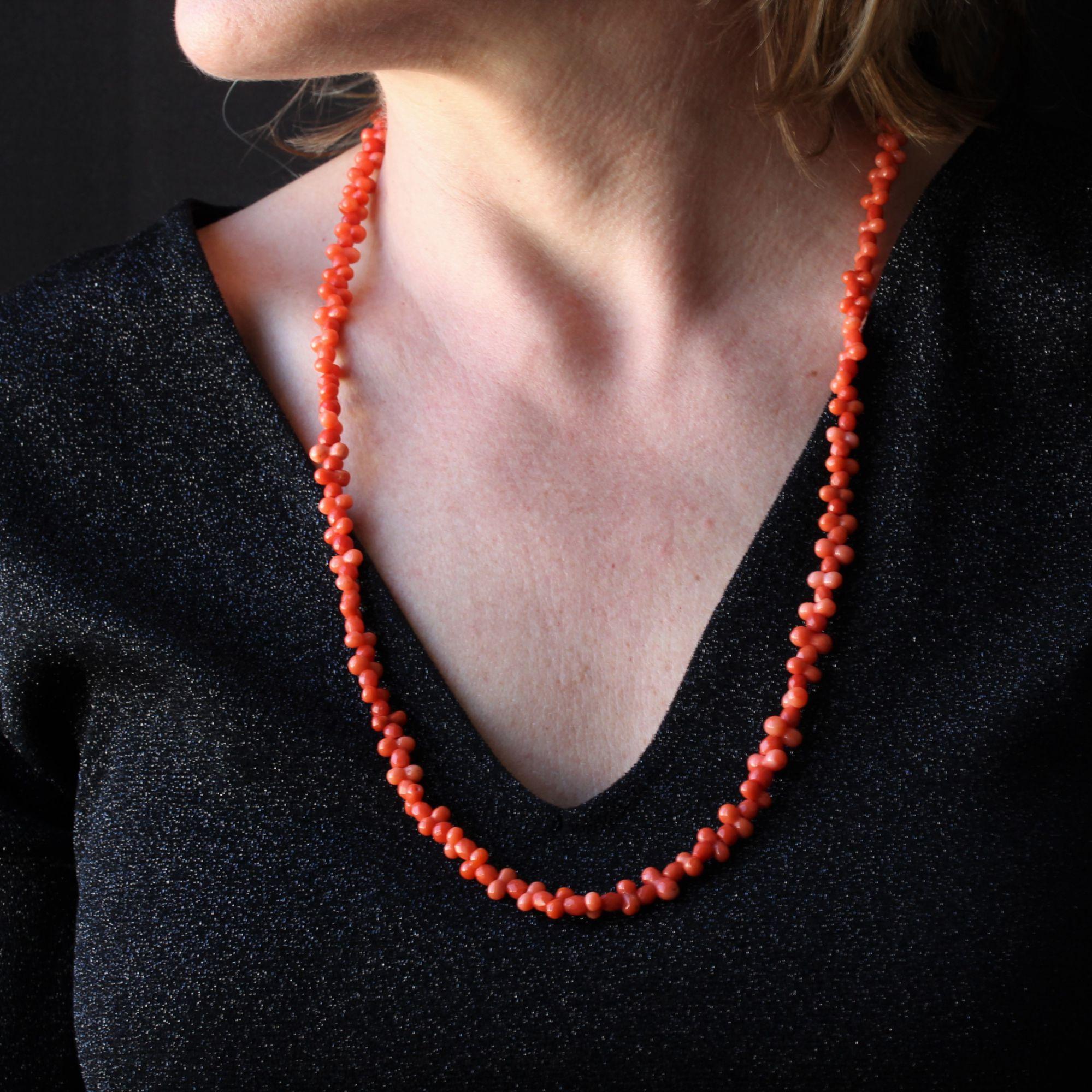 Necklace made of a fall of faceted coral pearls, alternated with double pearls.
The clasp of this antique necklace is ratchet with safety chain in 18 karat yellow gold. The latter is set with a cameo on coral representing the face and bust of a
