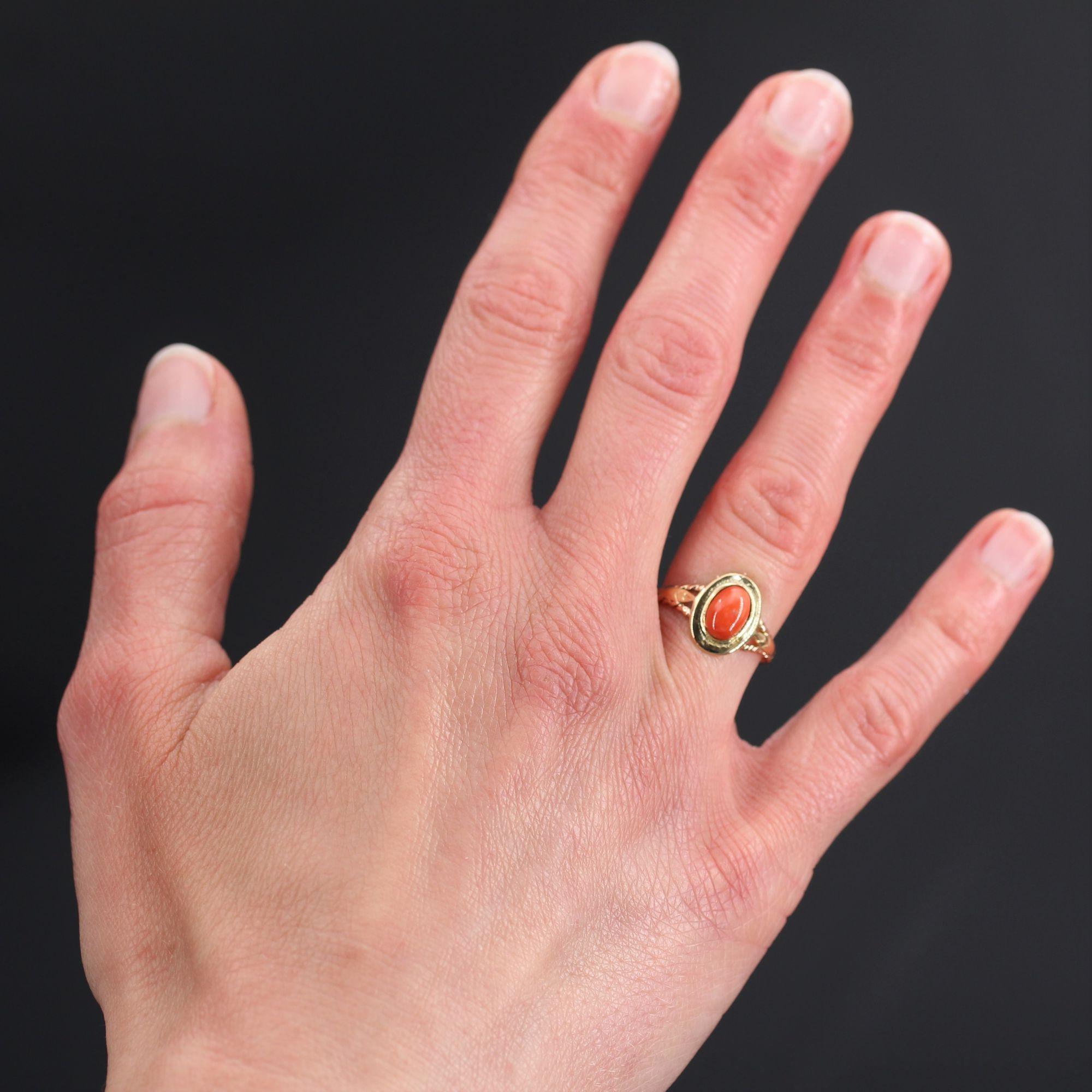 Ring in 18 karat yellow gold.
Charming antique ring, it is formed of a double ring in gold braid which holds on the top an oval pattern set in the center of a cabochon of Mediterranean coral. On both sides the start of the ring is formed by a chased