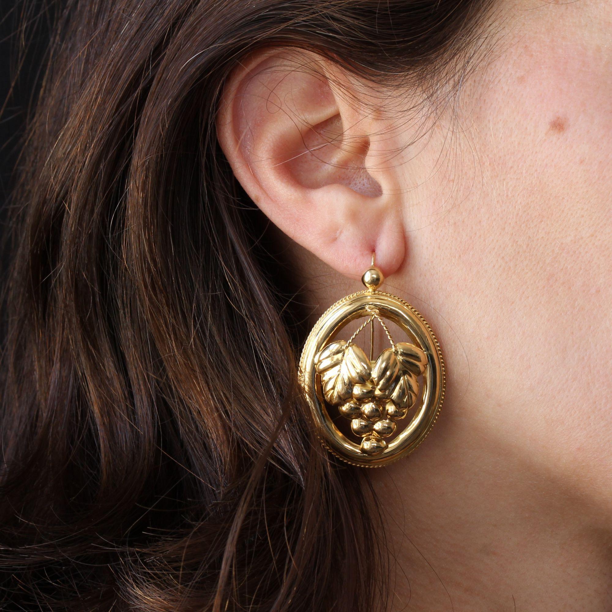 For pierced ears.
Earrings in 18 karat yellow gold, eagle head hallmark.
Imposing lever- back earrings of oval form, these antique earrings are openwork of a bunch of grapes and surmounted by a pearl. All around is bordered by a thin cord. The hook