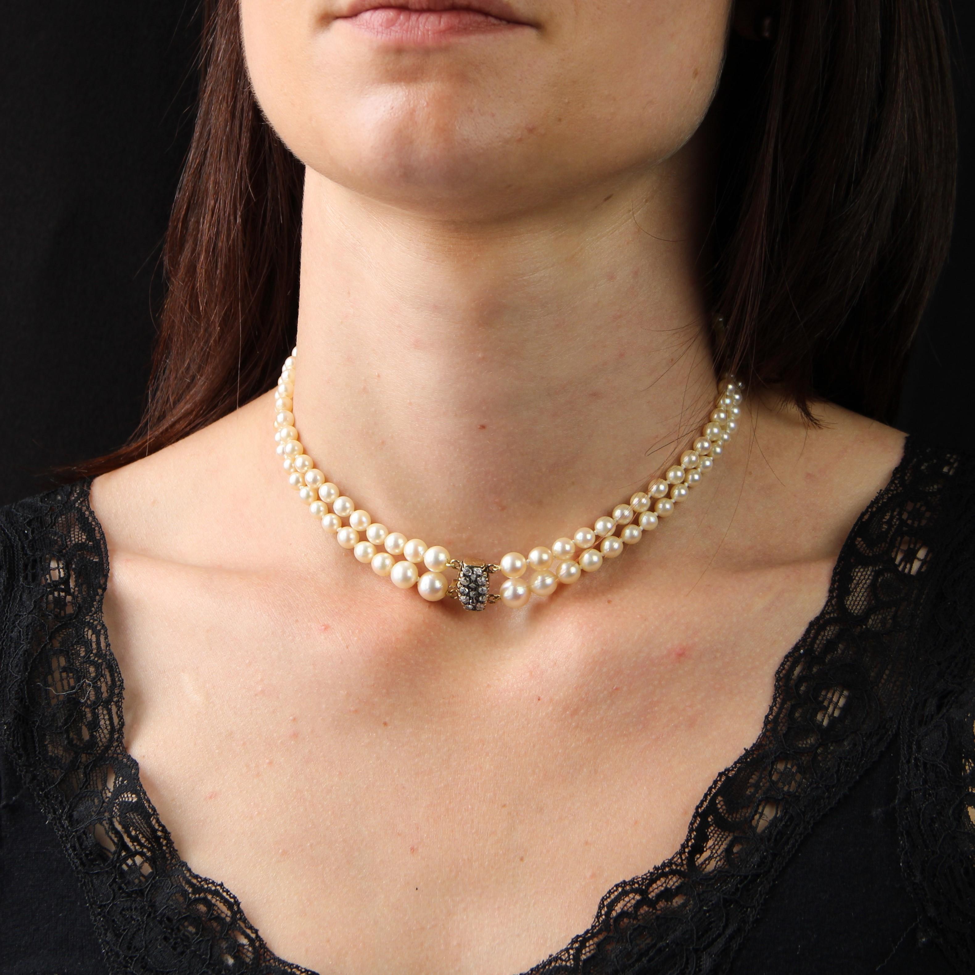 Necklace featuring a double strand of pearly creamy-white oriental round cultured pearls. The most important pearls are located on the clasp.
The clasp is in 18 karat yellow gold, owl hallmark. It is tonneau-shaped, ratcheted with security and set