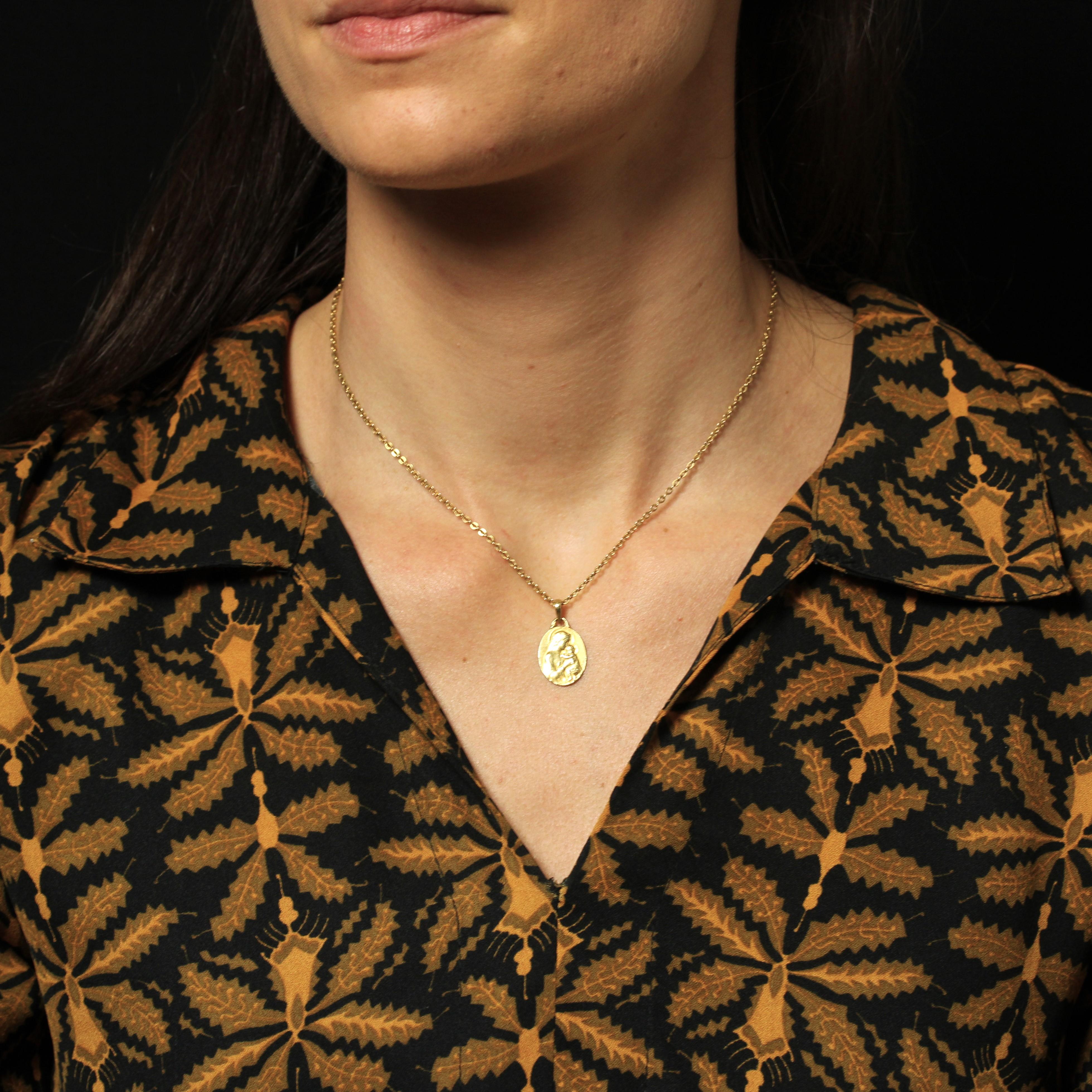 Medal in 18 karat yellow gold, eagle head hallmark.
A delightful oval-shaped antique medal depicting the Virgin Mary holding the infant Jesus in her arms. It is engraved on the back “Danièle Quesnoy 22 Mars 1936”.
Religious pendant signed