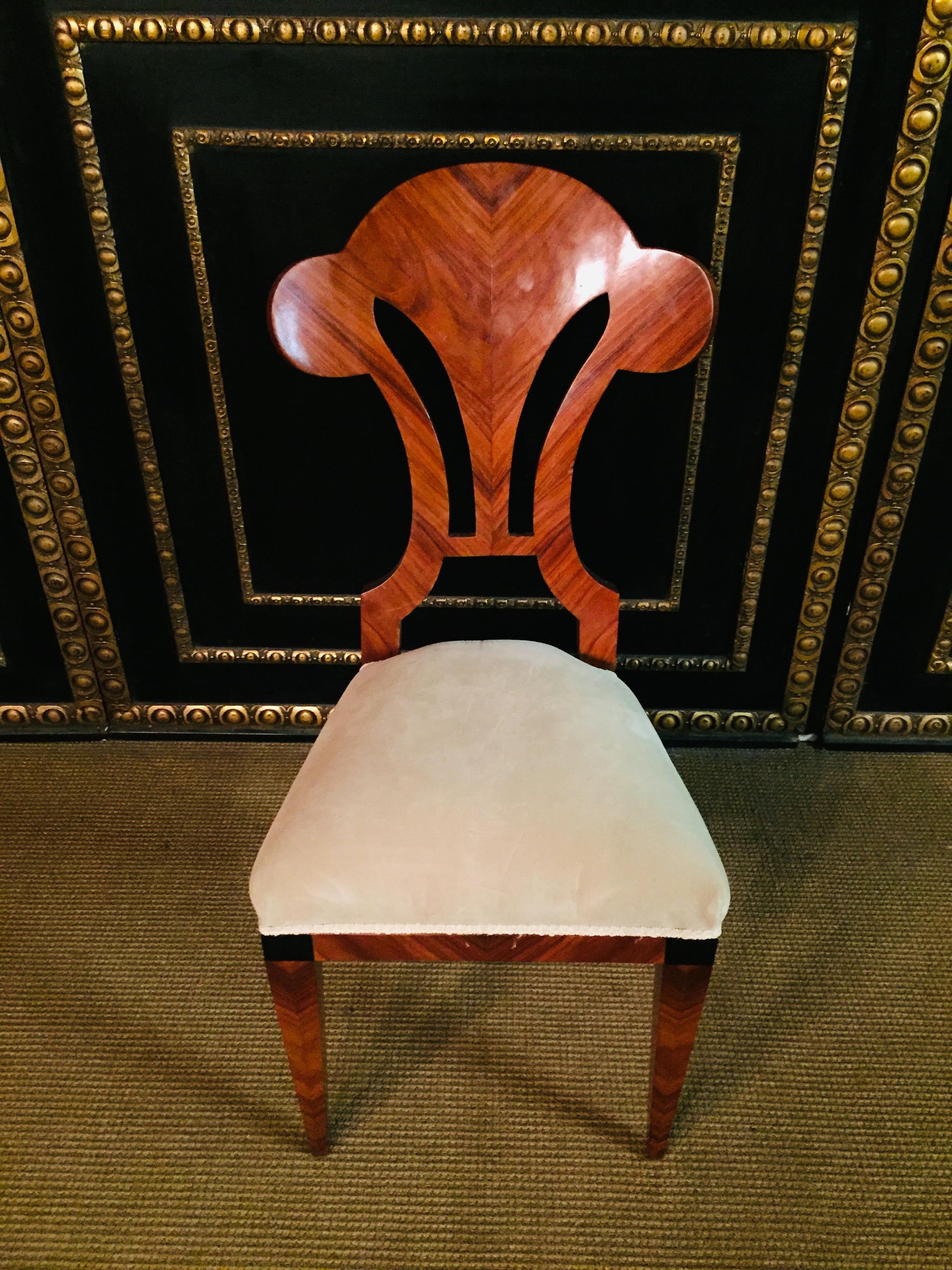 Solid beechwood with mahogany veneer. Tapered square legs. Straight frame. Extraordinary backrest, the shape of the backrest could be described as a three-leaf clover. Connected by a straight central bridge. Classically upholstered seat,
 