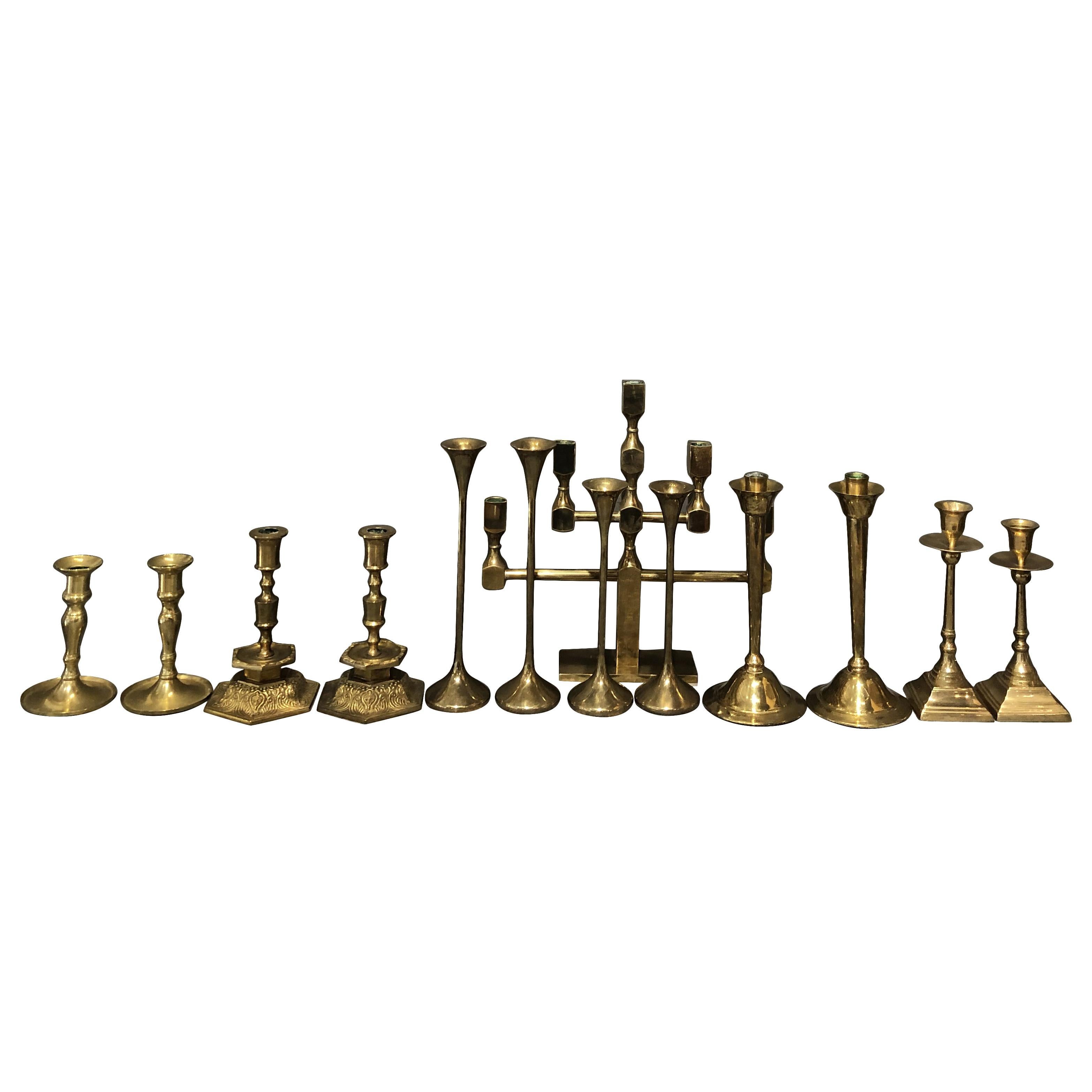 A vintage Mid-Century Modern set of fourteen finely worked candlesticks in a variety of shapes in brass, in good condition. Wear consistent with age and use, circa 1950, Sweden and Denmark, Scandinavia.