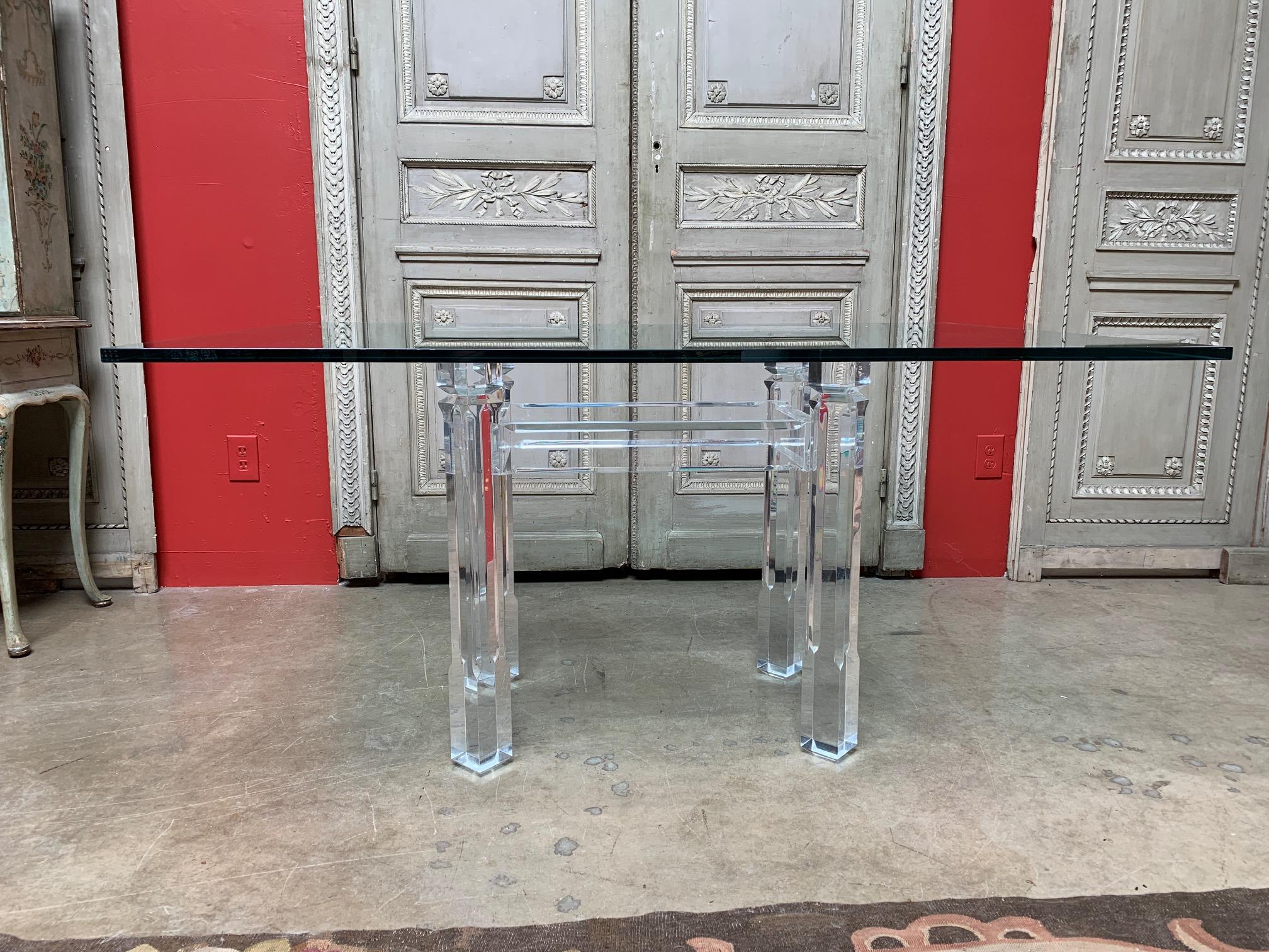 Acrylic four leg dining table with a retangular glass top from the late 20th century.