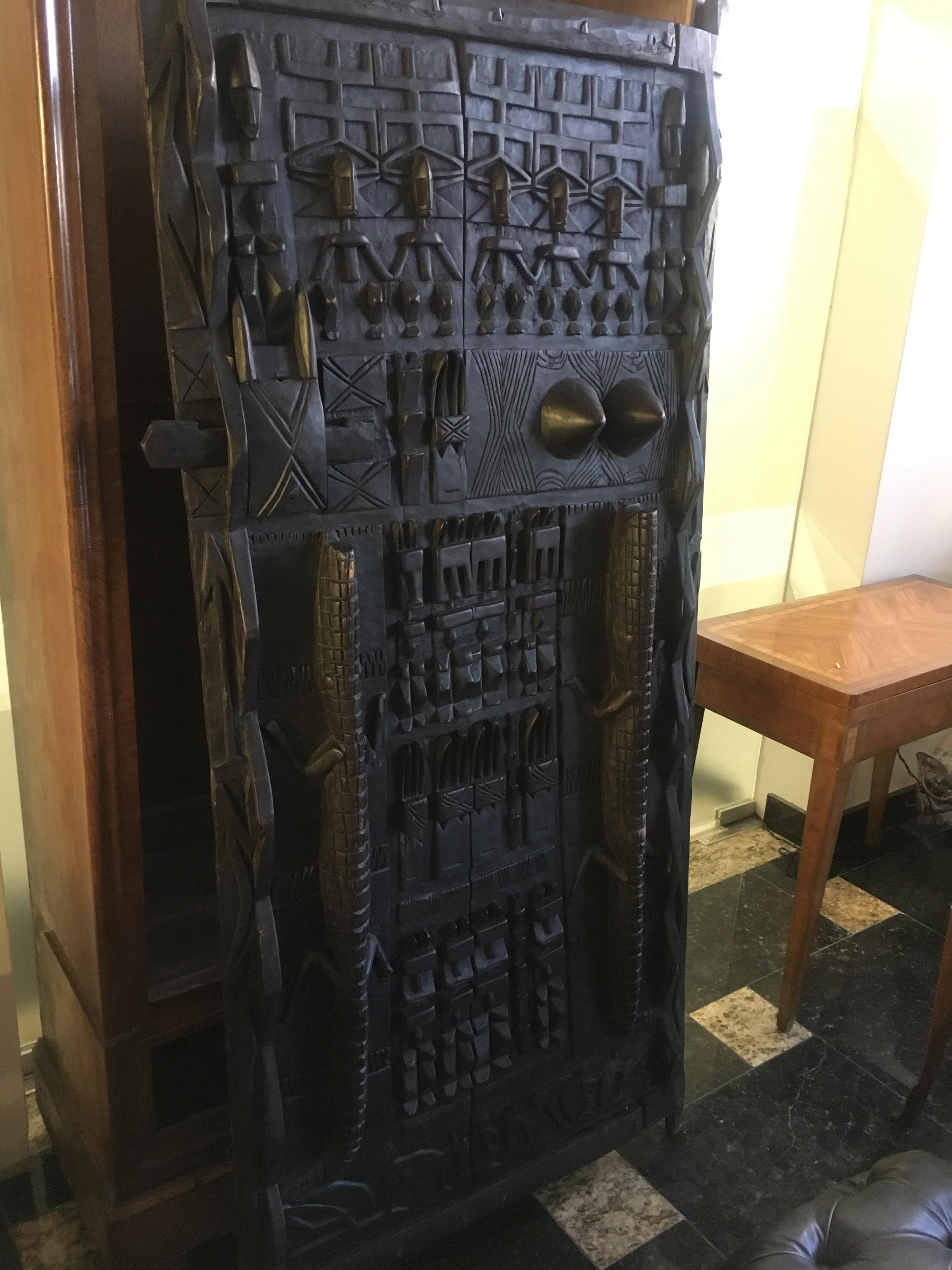 Carved wood door decorated with crocodiles, characters and geometric symbols. (This model of door is not symmetrical and presents differences of size from one angle to another)
Africa, circa 1900
Measures: 181 x 83 cm.