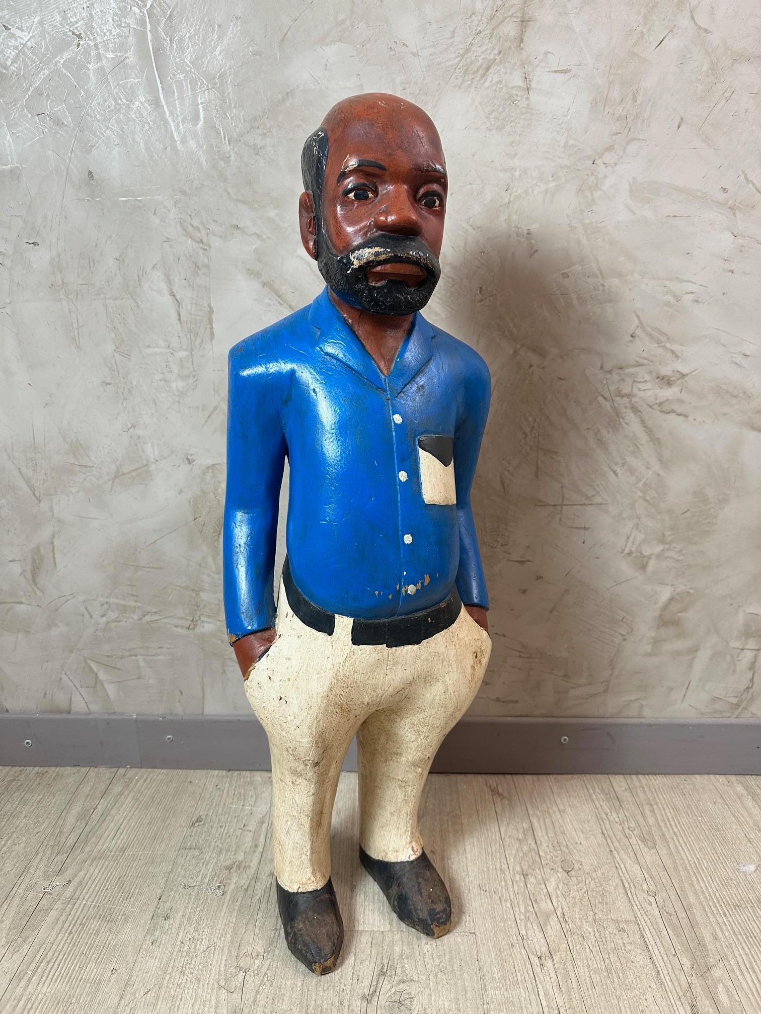 Beautiful colonial statue in painted wood probably dating from the 50s. 
Man dressed in a royal blue shirt and white belted pants. 
A colonial hat covers his head (several damages).
Statue in fair condition but will give your interior an ethnic