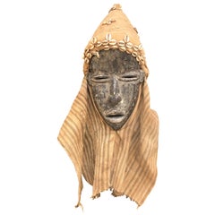 Masque africain Dan du 20ème siècle sculpté à la main en Liberia avec des coquilles de vache