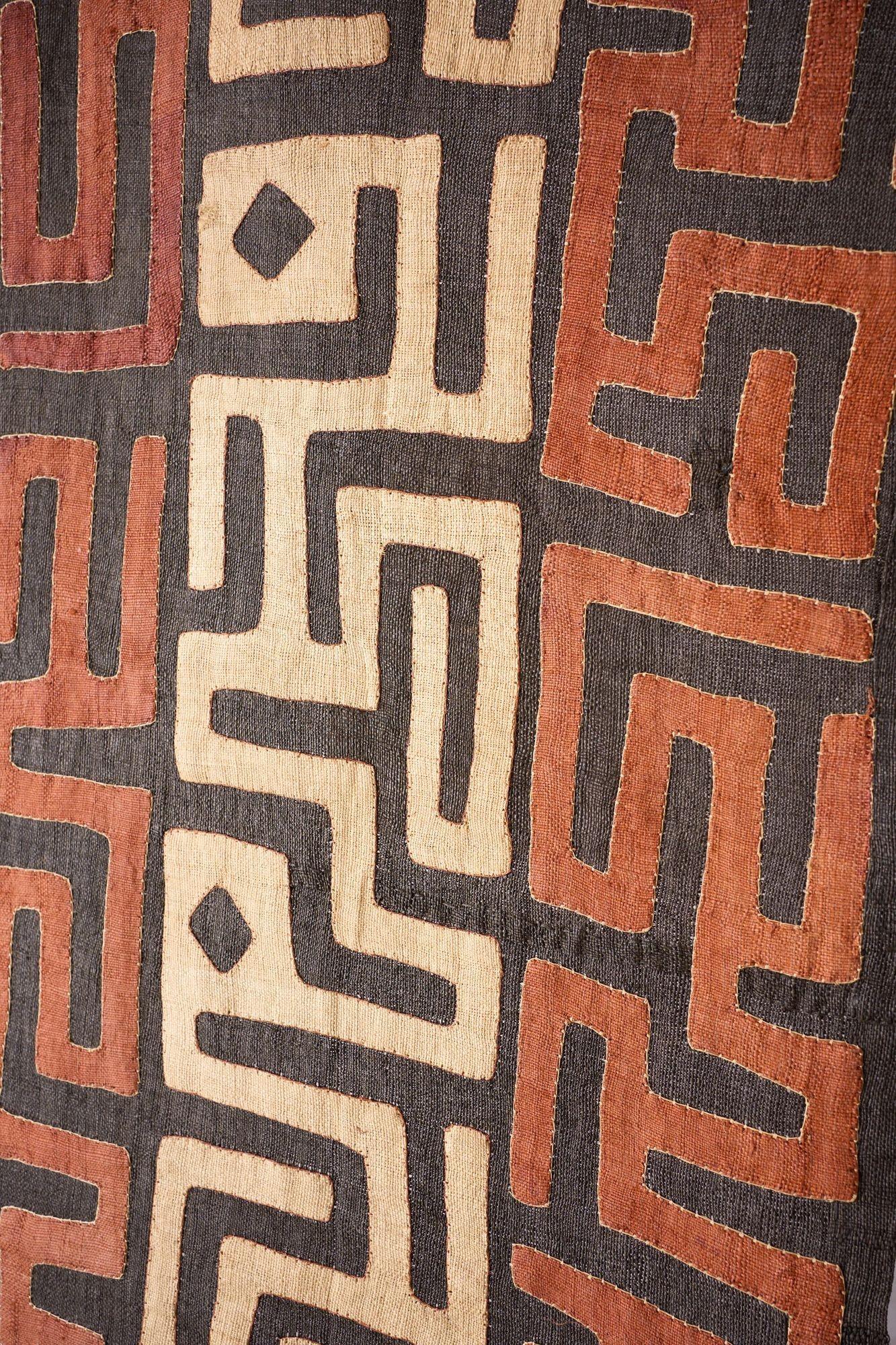 This is a hugely decorative and very long 20th century African Kuba cloth from the Congo. Made entirely by hand with applied abstract shapes to create this striking designed piece. Ideal as wall decoration are turned into cushions. No holes or