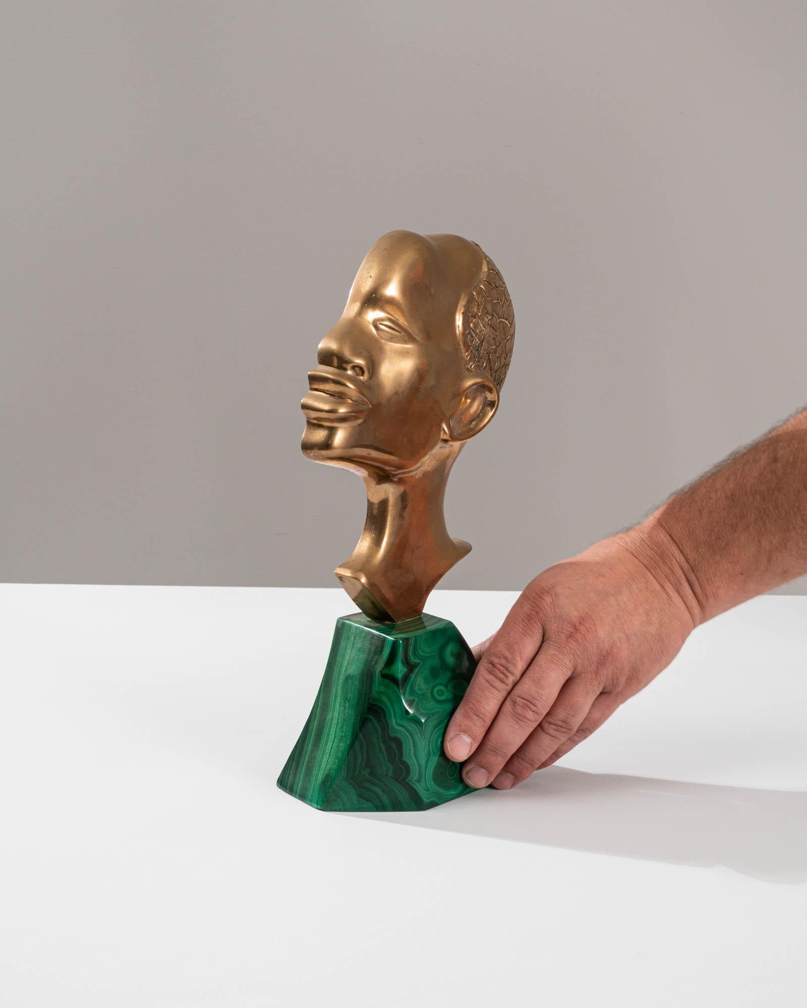 Introduce a touch of African elegance to your space with this 20th-century African Marble Decoration. Resting on a verdant block of marble, this captivating piece features a beautifully crafted brass bust of an African man. The green marble serves