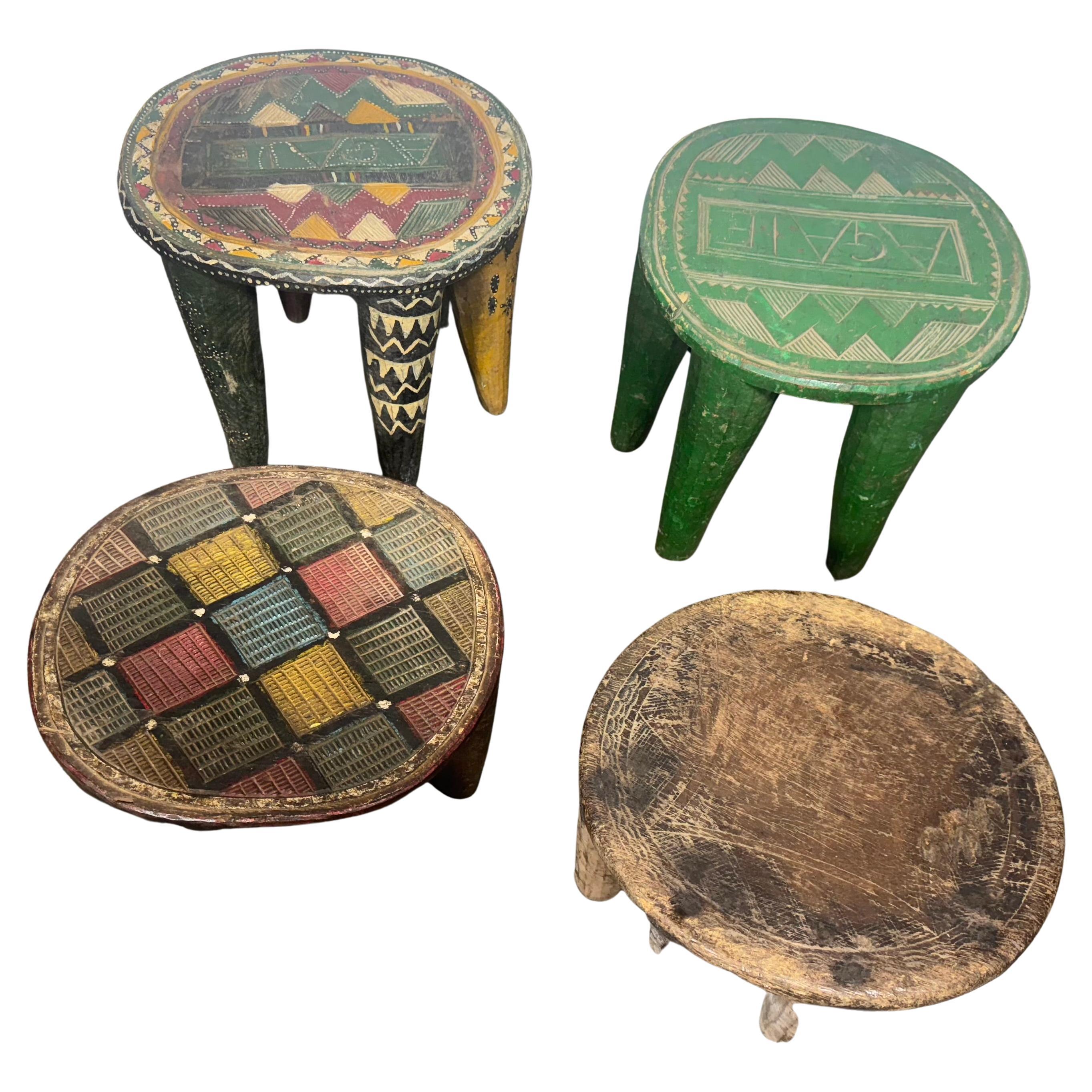Nigeria, milieu du XXe siècle. Trois  tabourets en bois sculptés à la main par la communauté Nupe. NOTE ^^^ LE TABLEAU VERT A ETE VENDU,,, Chacun a une forme ronde avec des pieds coniques et un dessus richement incisé. 3 peintures à la main.  La
