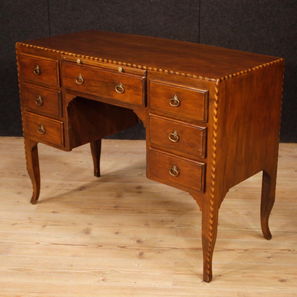 20th century Italian writing desk. Furniture in African walnut and boxwood of beautiful line and excellent proportion. Writing desk with a top in character, 7 drawers and extractable front top, of good service. Desk finished for the center, ideal to