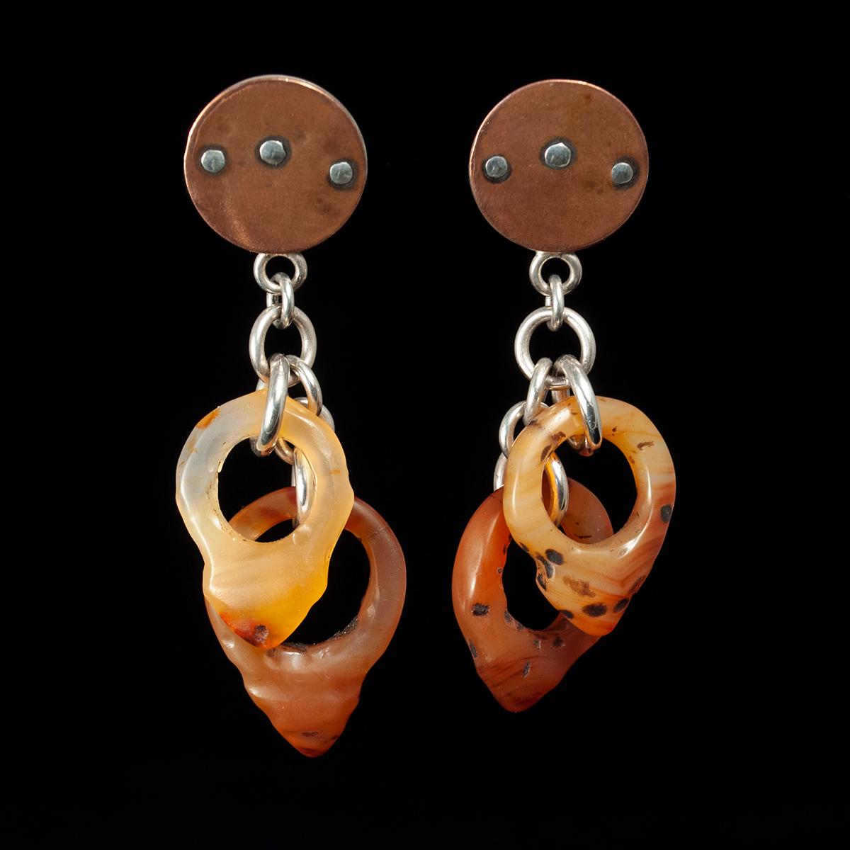 20th Century Agate and Silver earrings by Jewels

Four rare hair ornaments carved in agate, called Tanfouk or Talhakimt, drop from a copper and silver disk for a pair of lightweight earrings. These ornaments were worn by women in Mali and Mauritania