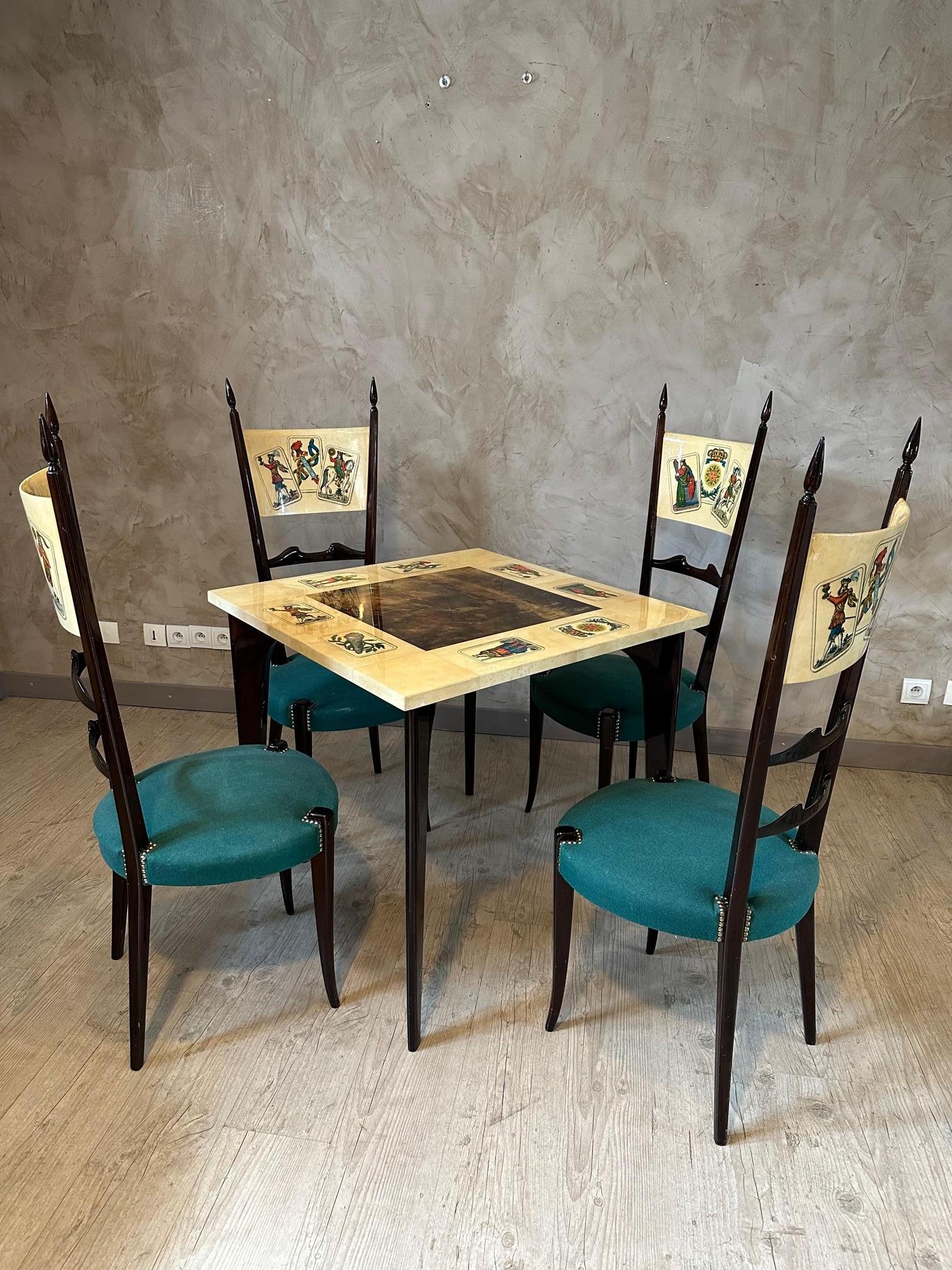 Rare piece! Very beautiful Italian game table Aldo Tura from the 60s in lacquered walnut, sheathed in lacquered goatskin and parchment with its four chairs. Representation of tarot cards.
High-backed chairs (one end of a chair has been glued), green
