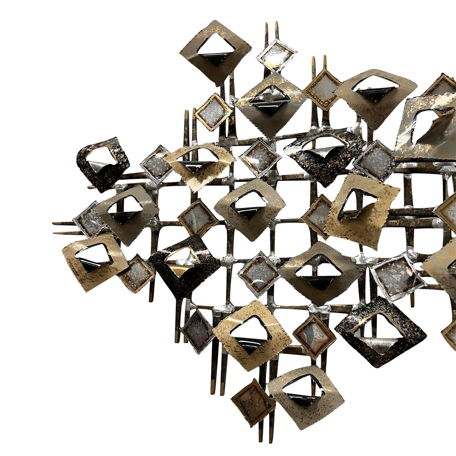 A black-grey, late vintage Mid-Century Modern American abstract Brutalist wall sculpture made of hand crafted gilded metal, designed by Linda Casetti in good condition. The detailed large wall décor piece is enhanced by small metal pieces,