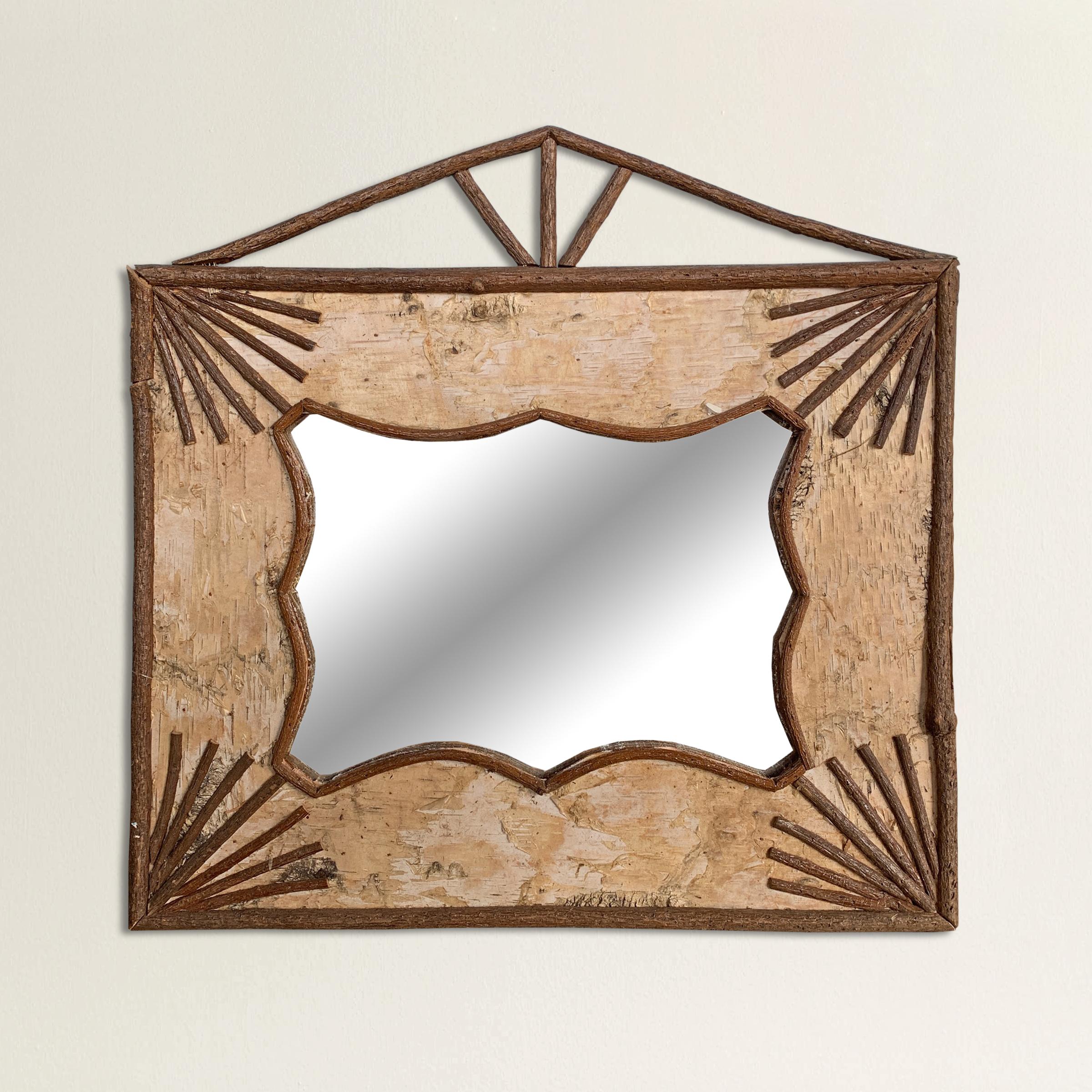 A charming mid-20th century American Adirondack-style birch bark framed mirror with applied twigs forming a roof line at the top and starbursts in the corners.