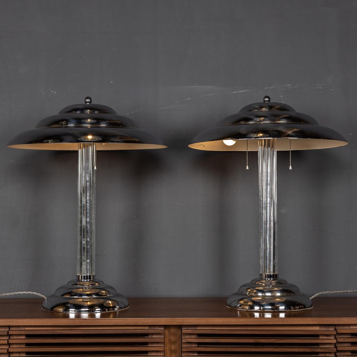 20th Century pair of American Art Deco table lamps in chrome with glass rod detail. Each lamp has two bulbs and a chain pull switch, c.1930s

Condition
In great condition - wear and tear consistent with age.

Size
Diameter: 50cm
Height: 67cm.