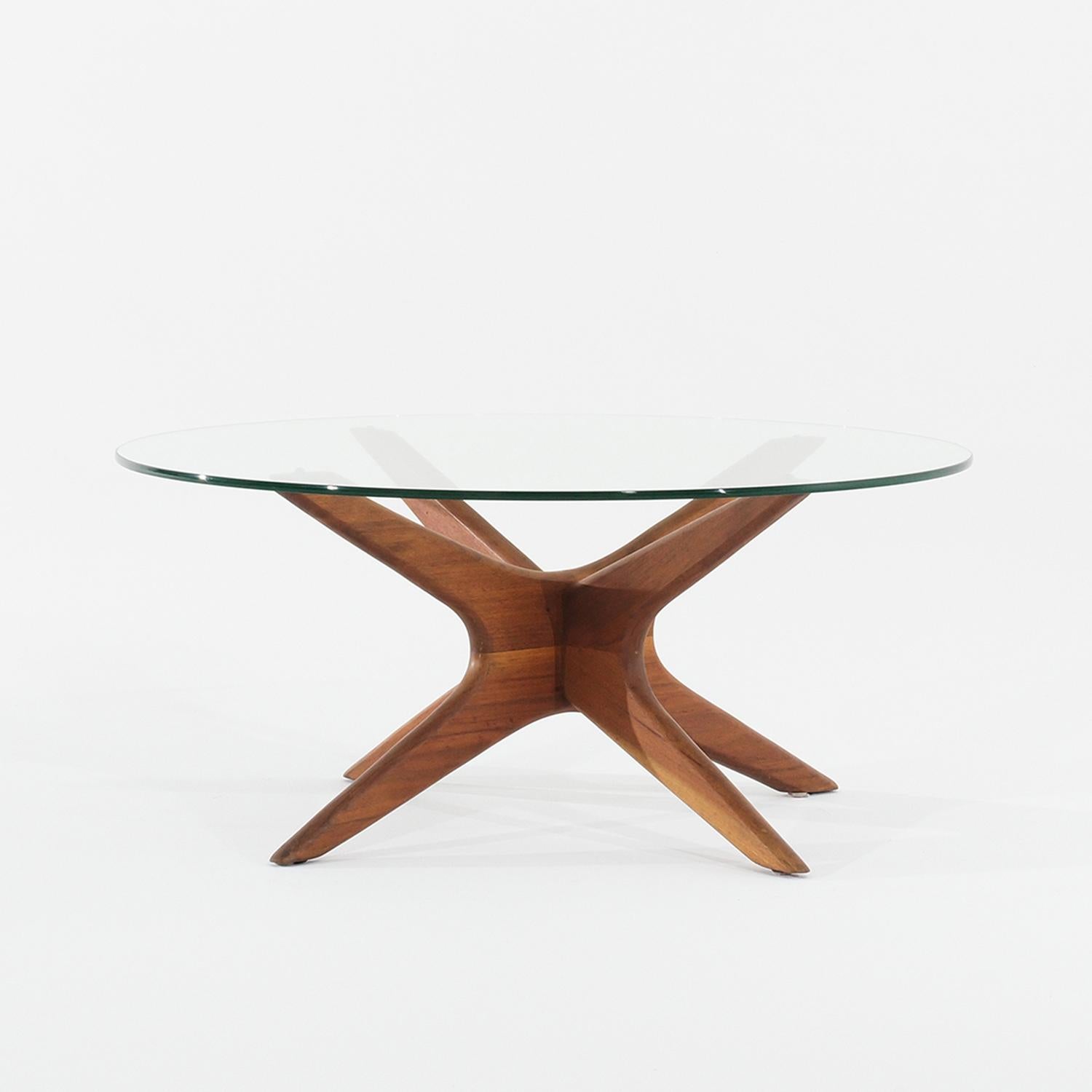 A round, vintage Mid-Century modern American coffee, sofa table made of hand crafted polished Walnut, designed by Adrian Pearsall and produced by Craft Associates in good condition. The original slightly smoked glass top is supported by four