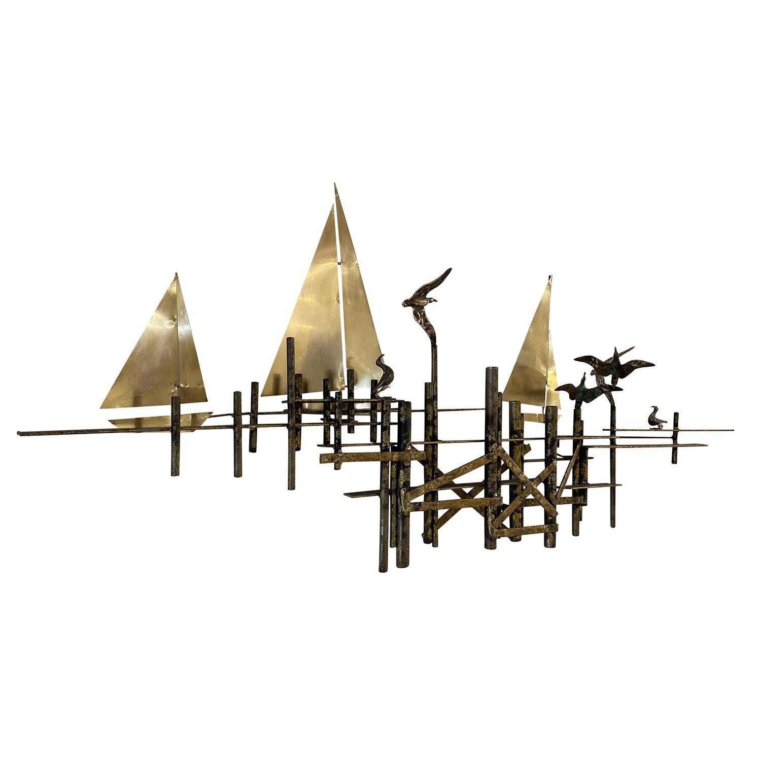 A black-grey, vintage Mid-Century Modern American abstract Brutalist wall sculpture made of hand crafted gilded metal, designed and produced by Curtis Jere in good condition. The detailed wall décor piece depicts three sailboats and shorebirds at