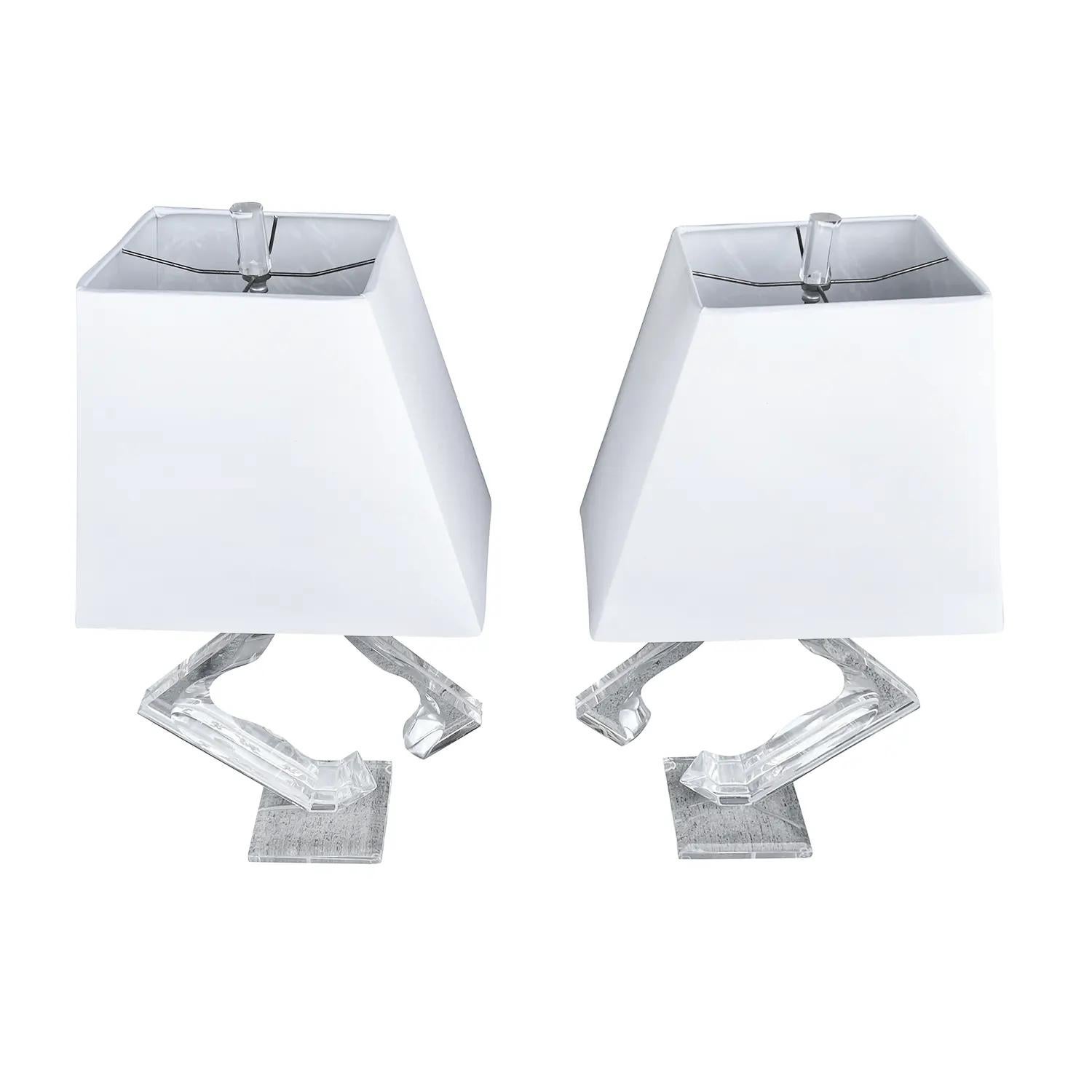 A vintage Mid-Century Modern American pair of sculptural table lamps made of hand crafted chromed metal and lucite glass, designed by Hivo Van Teal in good condition. The clear acrylic desk lights are composed with a new white shade, featuring a two