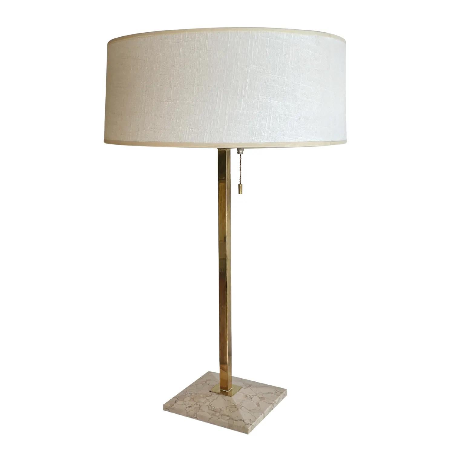 Une grande lampe de table vintage de style américain Mid-Century Modern en laiton poli fait à la main, conçue par Gerald Thurston et produite par Lightolier, en bon état. La lampe de bureau est composée d'un abat-jour rond en lin blanc-jaune et d'un