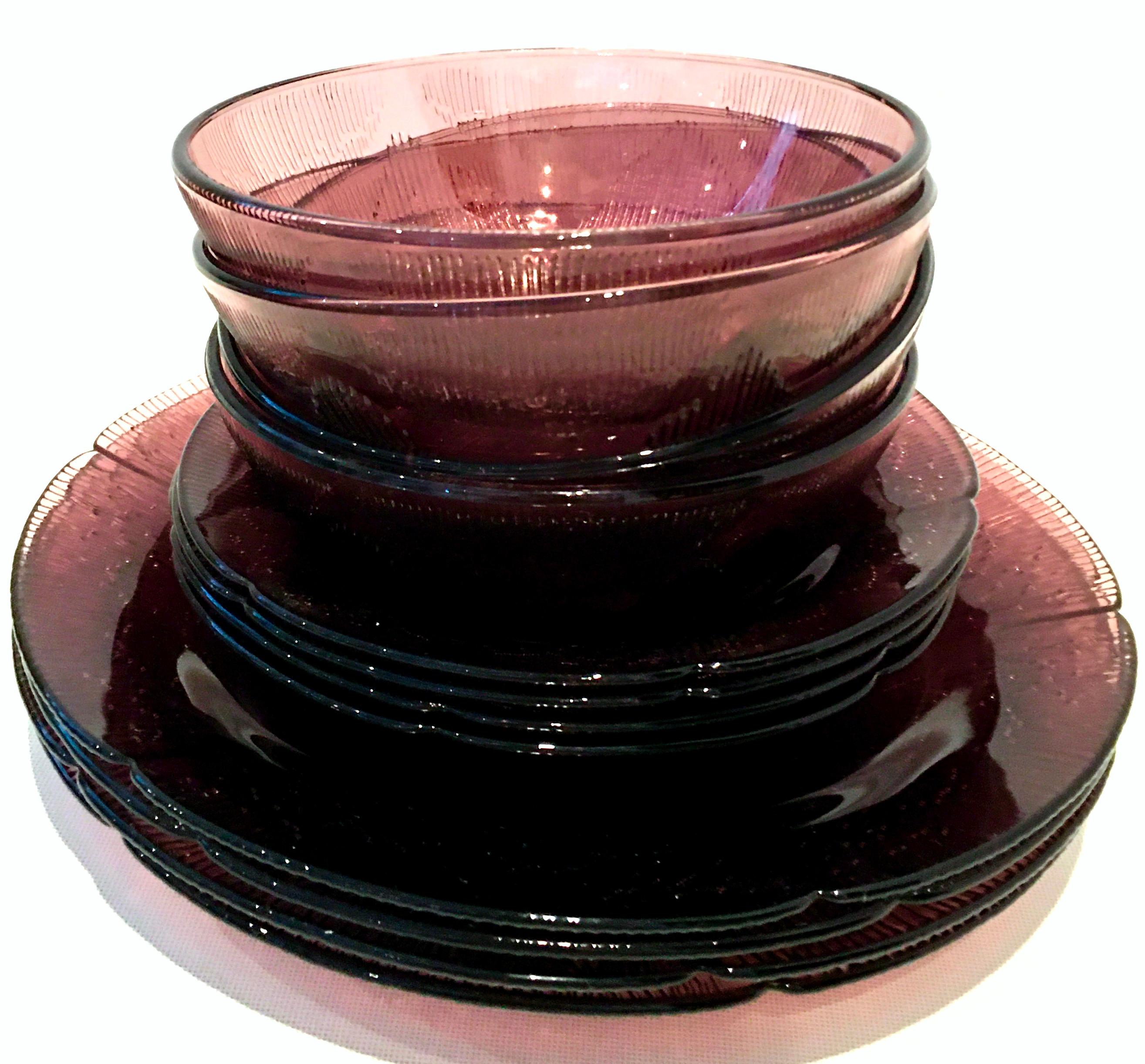 20th century American pressed glass amethyst dinnerware set of twelve pieces. This twelve piece amethyst dinnerware set features a textured and big print floral pattern on the underside of each piece. Set includes four of each, dinner plate, soup