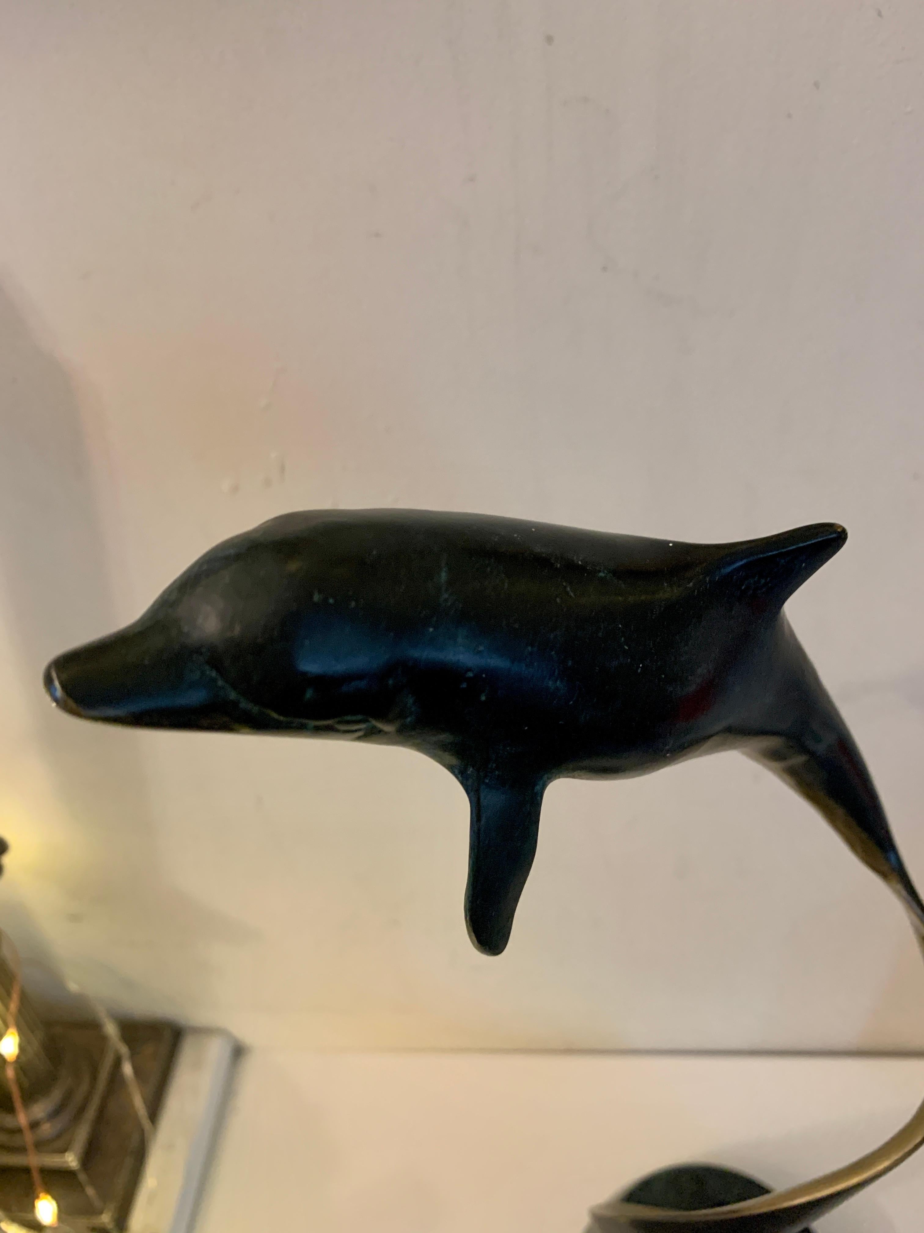 Well-modeled 1970s modern American Bronze of a Swimming, turning Dolphin.

Mounted on a marble base this piece has all the movement and style that was typical of the 1970s

The piece seems to have been cast in one piece and is in great original