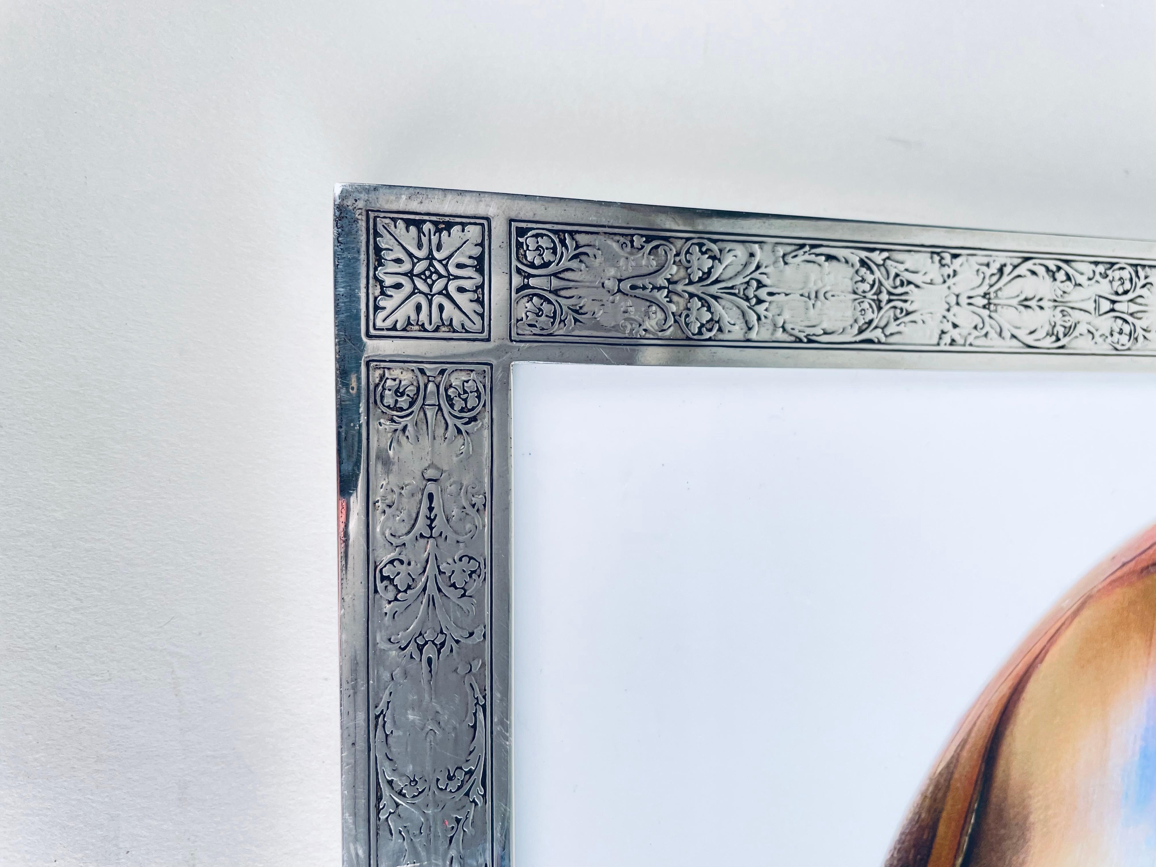 An early 20th century American Art Nouveau sterling silver and wood picture frame by, Tiffany & Co. with hand chased scroll motif throughout, without monogramming, retains its original wood and sterling back. The frame is signed Tiffany & Co. Makers