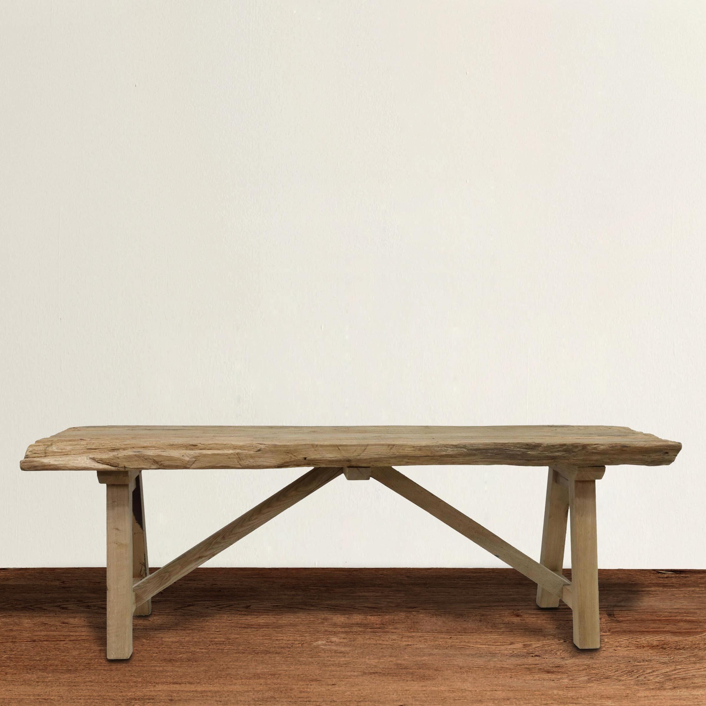 A strapping 20th century American trestle table with A frame legs supporting a live edge oak slab, all with a weathered bleached finish. Perfect as a console table behind a sofa, in your entry, or under a TV in your family room.