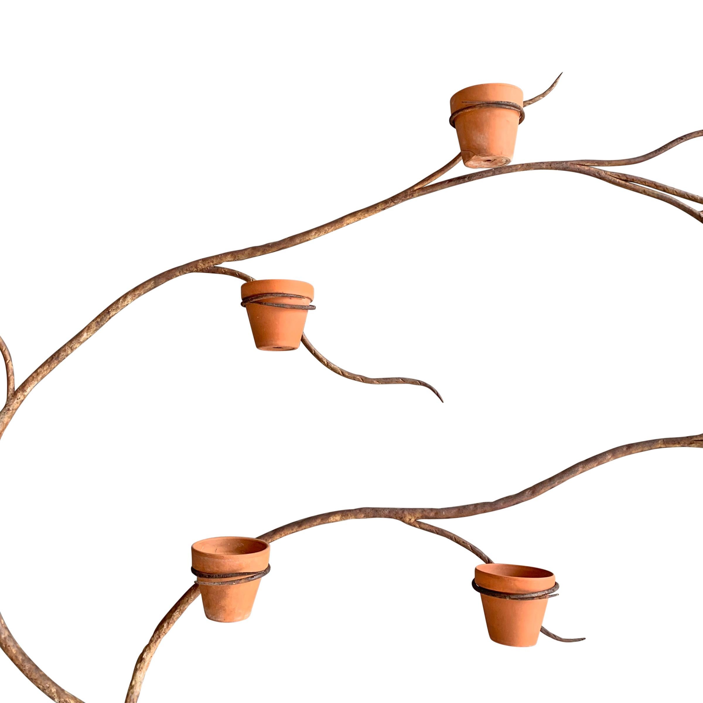 A incredible and whimsical early 20th century French artist-made wrought iron espalier planter with twenty-two rings that hold four inch terracotta pots. This piece was completely handmade and shows signs of a metalsmith's hand. It's composed of two