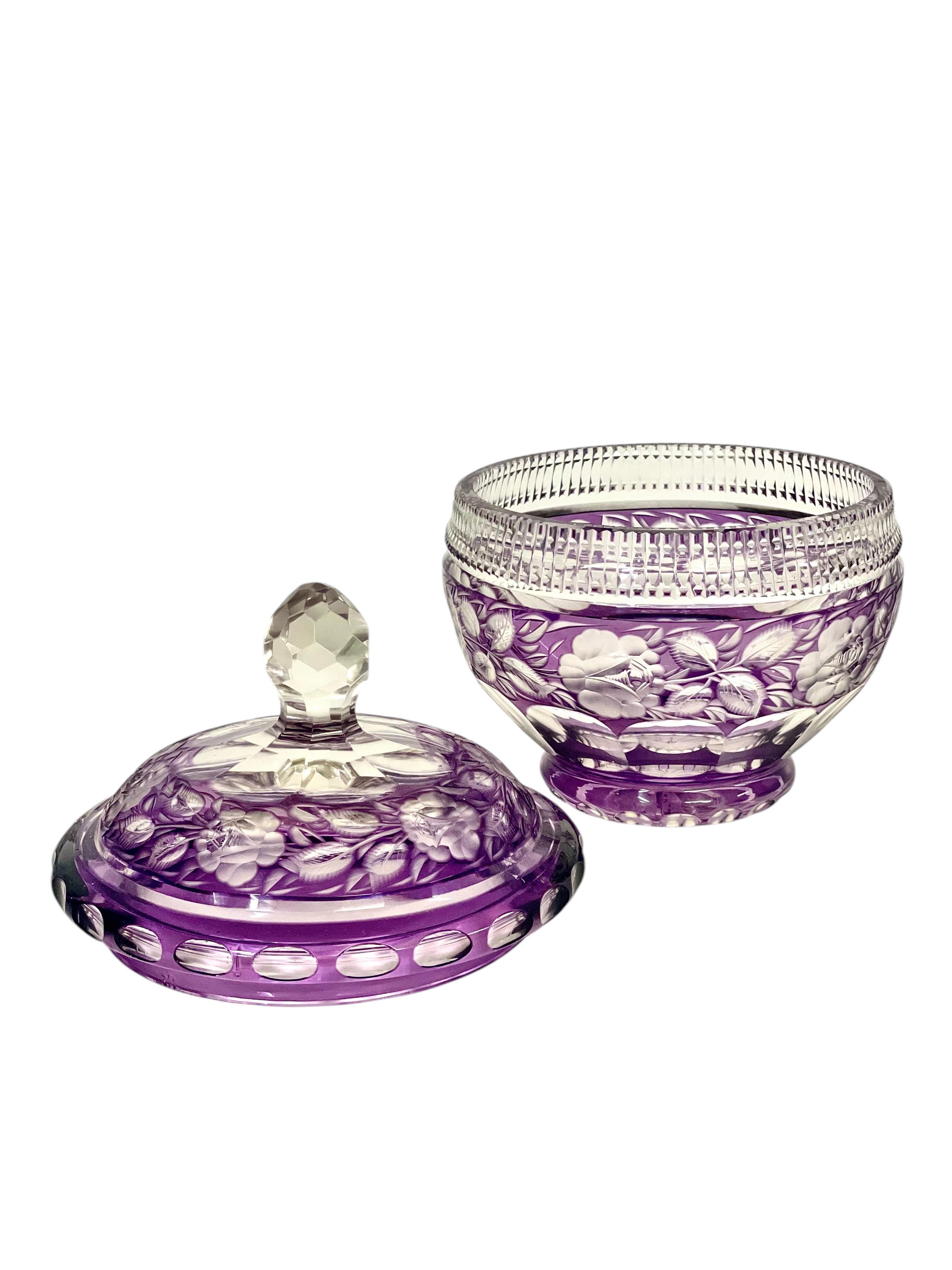 An adorable amethyst cut to clear crystal candy dish, or 'bonbonnière', featuring an intricate design of matt cut roses and foliage on its lid and bowl, with circular lenses around the rim and base, which catch and refract light beautifully. Shaped