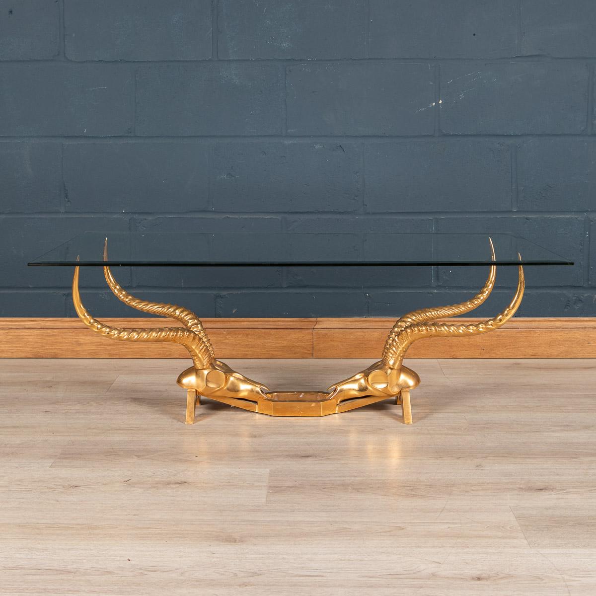 A vintage glass-topped coffee table with gold antelope skull and horn base designed by Dikran Khoubesserian for Fondica. Dikran Khoubesserian (1913-1991) was born into an Armenian family in Mersina, Turkey. At the age of ten he was sent to Paris