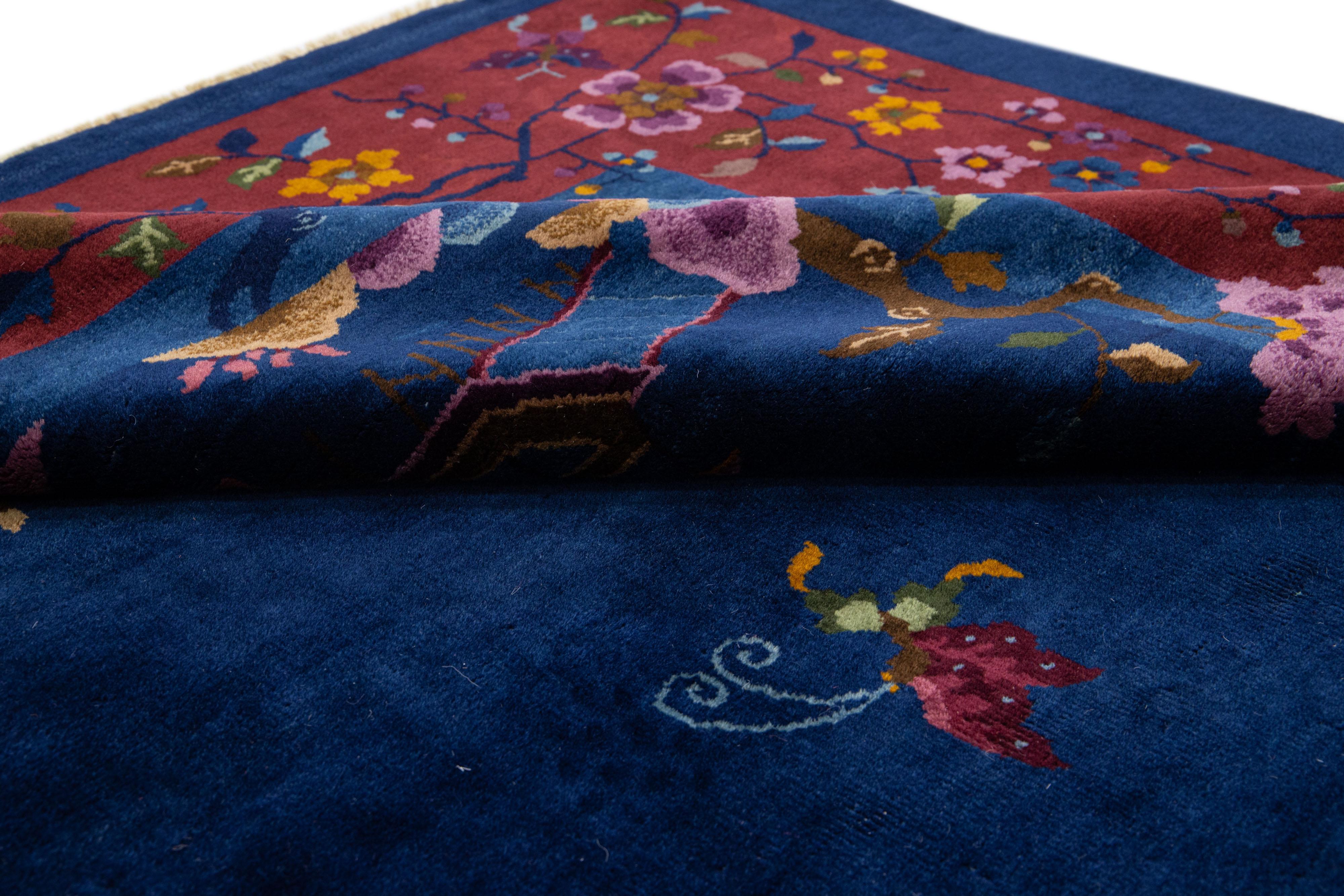 Beautiful antique Art Deco hand-knotted wool rug with a navy blue field. This piece has a red frame with multi-color accents in a gorgeous traditional Chinese floral design. 

This rug measures: 9'1