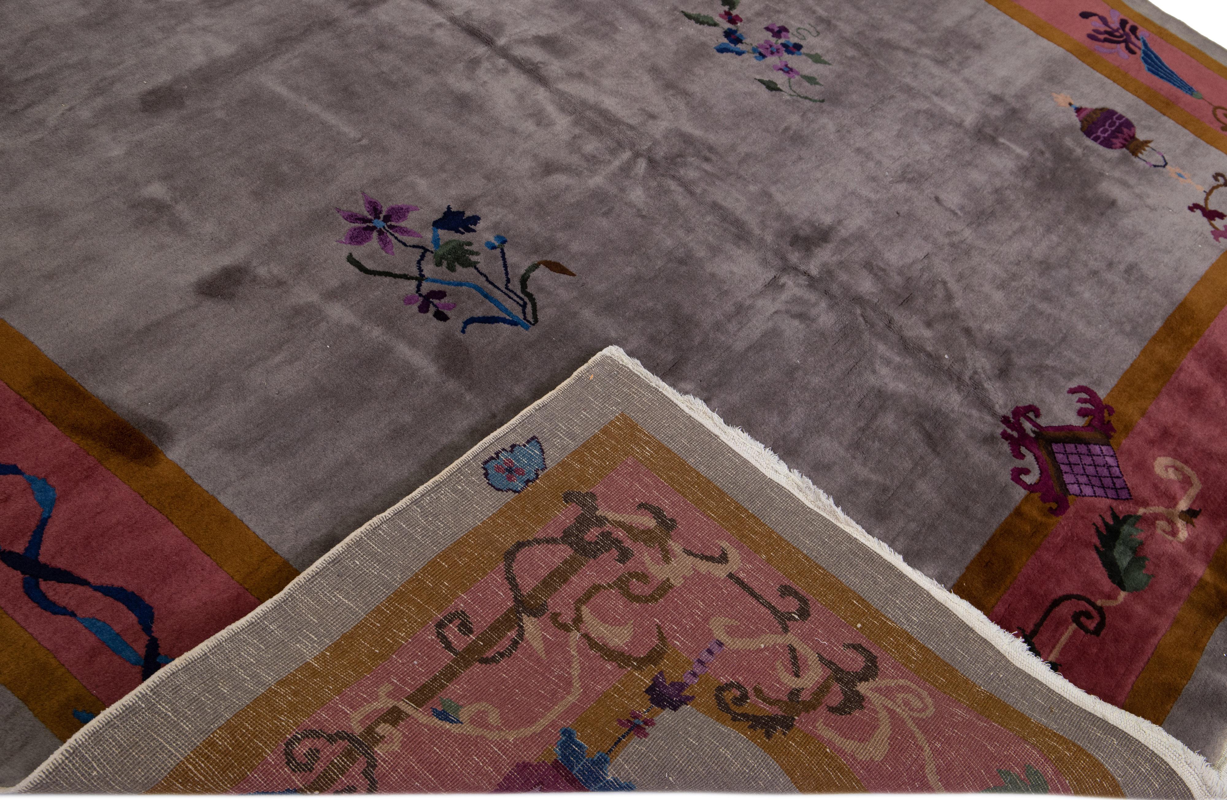 Magnifique tapis Art Déco antique en laine nouée à la main avec le champ gris. Ce tapis chinois présente un cadre bordeaux et doré avec des accents multicolores dans un magnifique motif floral chinois traditionnel. 

Ce tapis mesure : 9' x