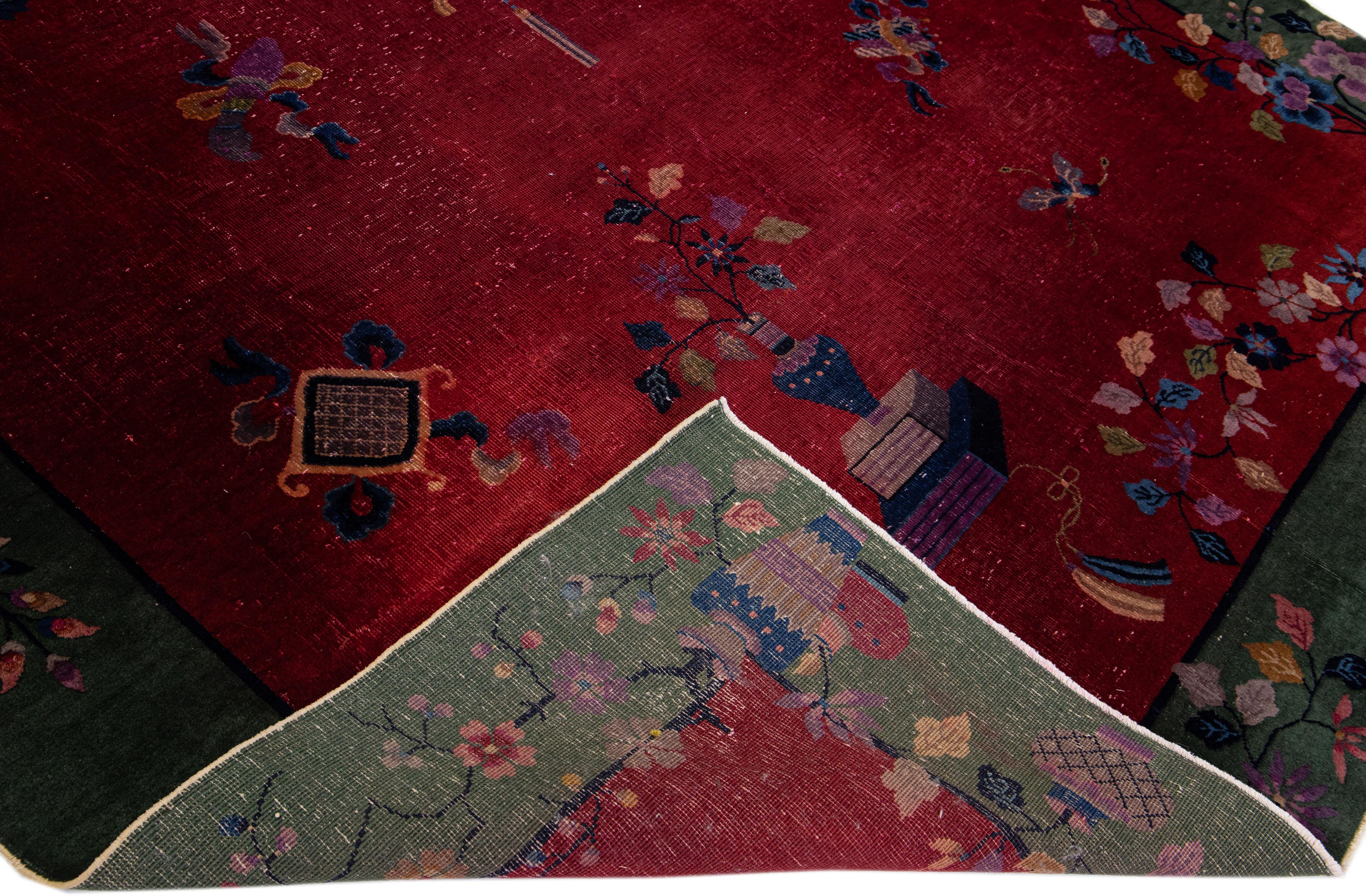 Beautiful antique Art Deco hand-knotted wool rug with a red field. This piece has a green frame with multi-color accents in a gorgeous traditional Chinese floral design. 

This rug measures: 8'1