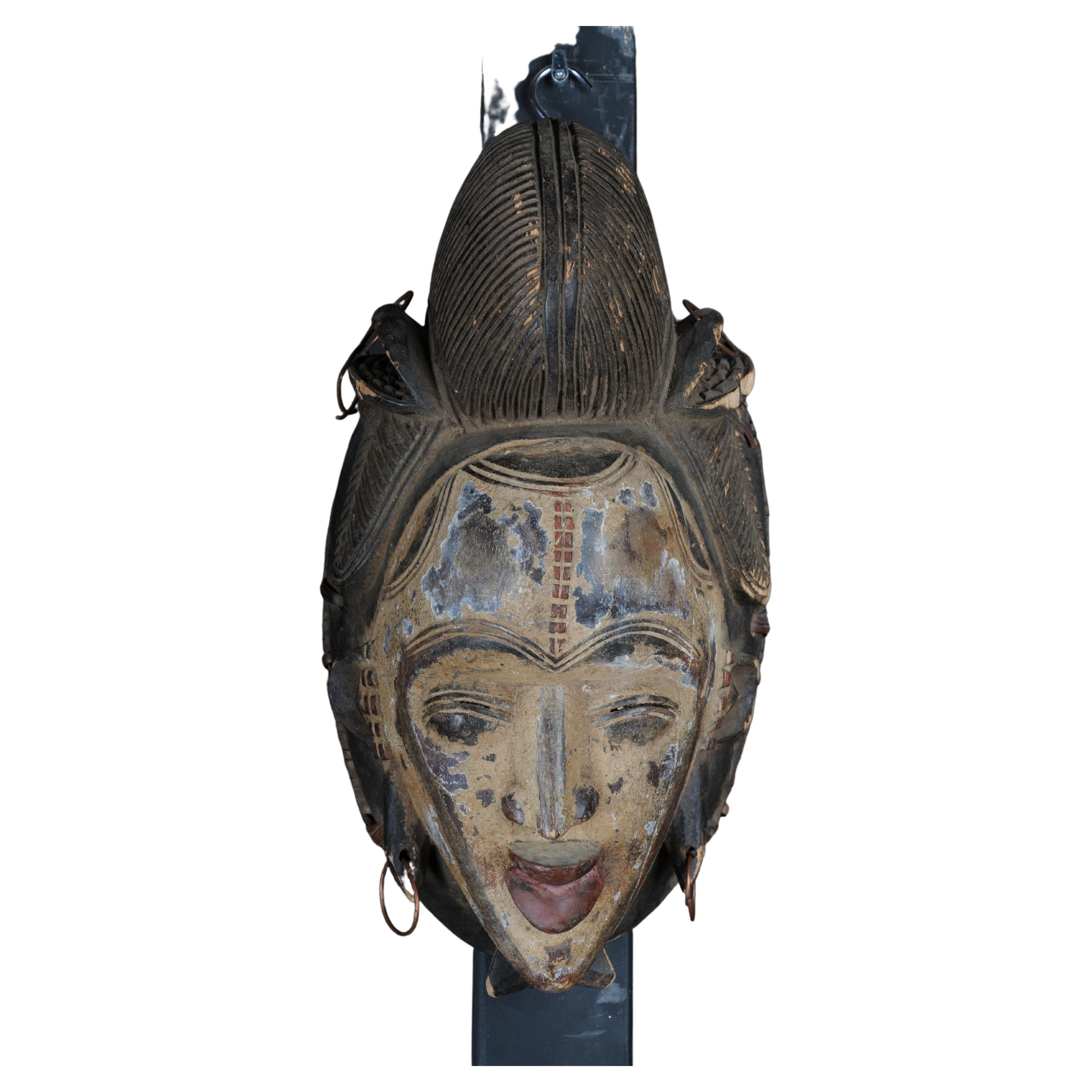 Máscara facial antigua de madera tallada del siglo XX, arte popular africano. Colgable.Decorat