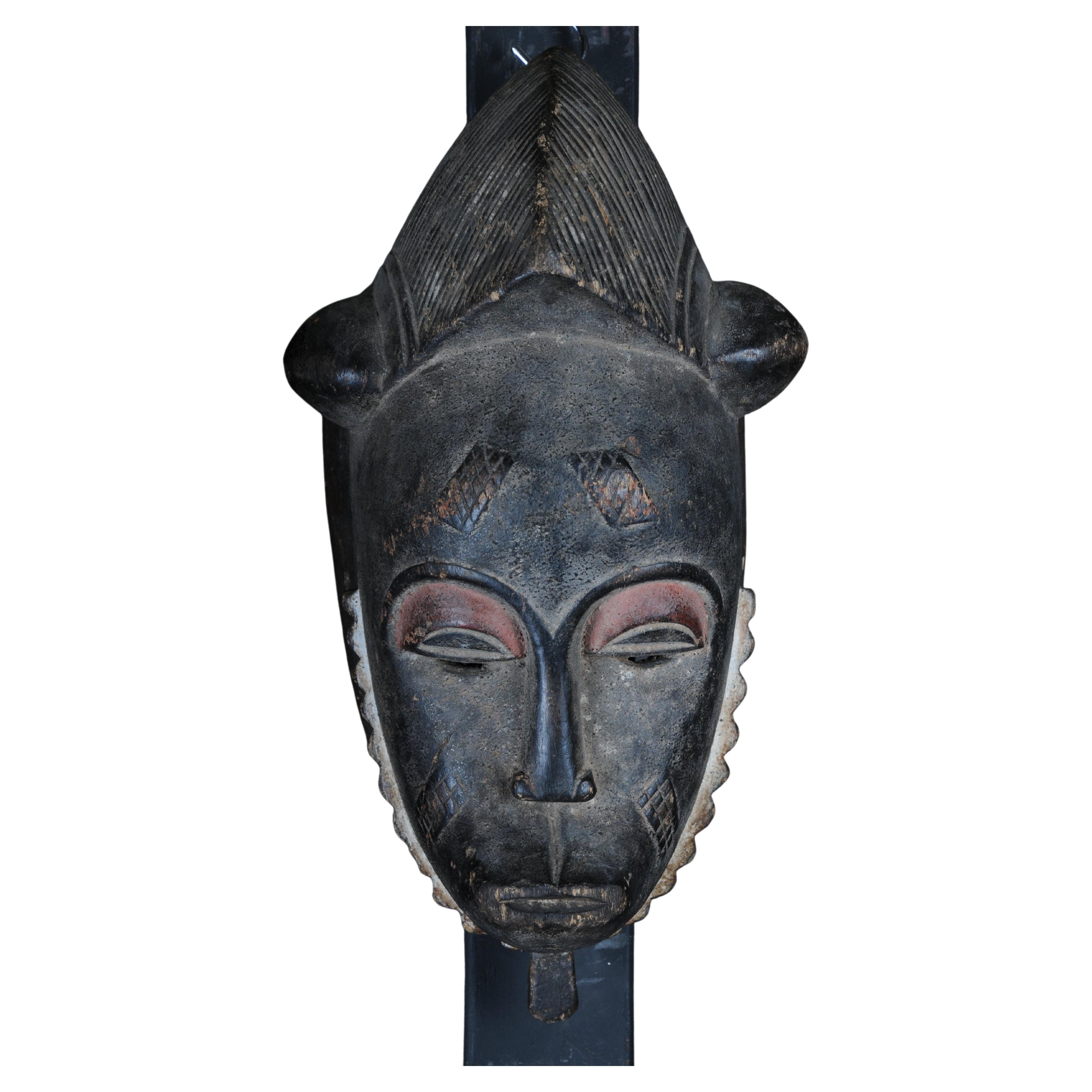 Máscara facial antigua de madera tallada del siglo XX, arte popular africano. Colgable.Decorat
