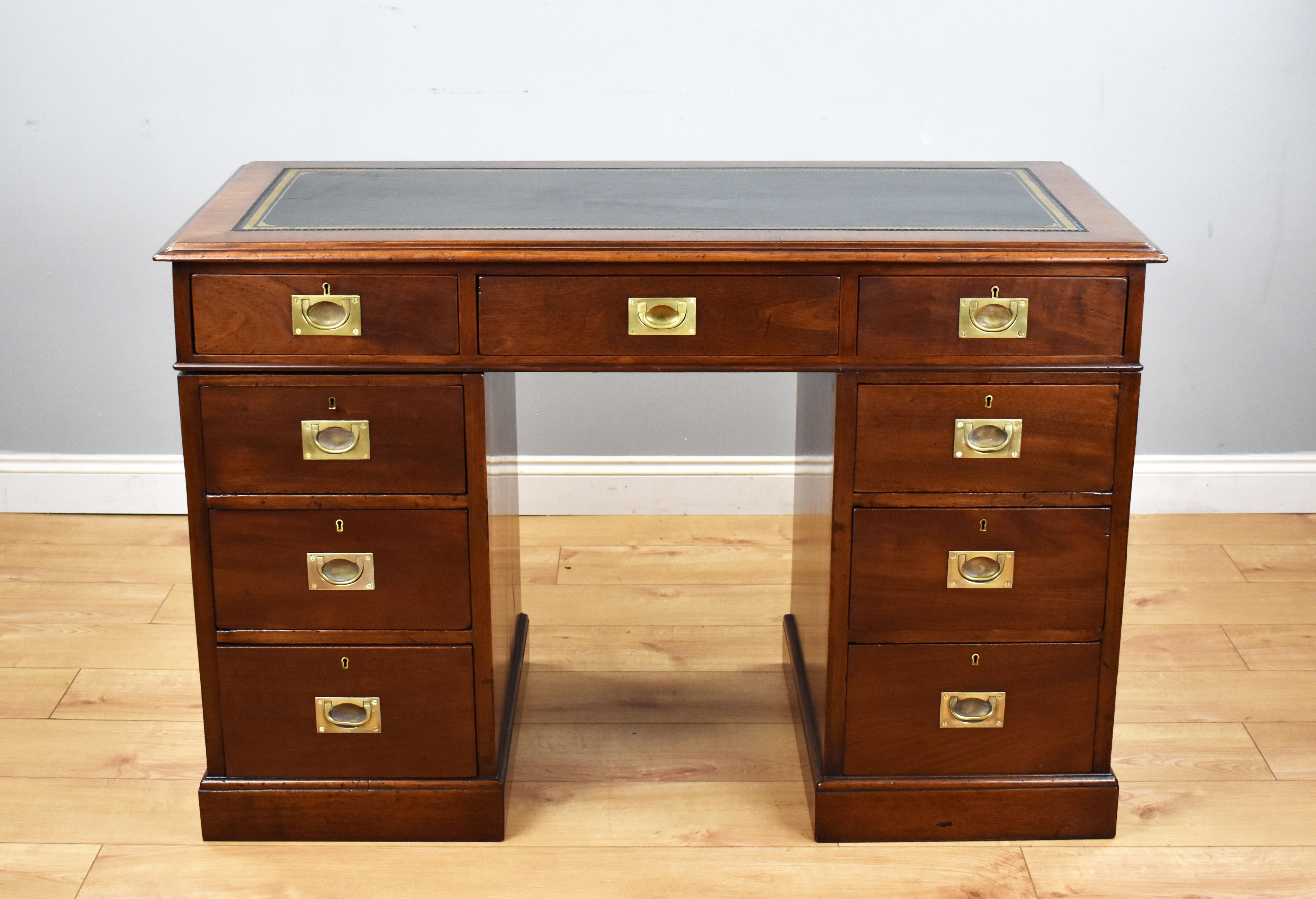 For sale is a good quality antique Campaign style mahogany pedestal desk, the top having an inset black leather skiver, decorated with gold tooling, above three drawers, each with brass Campaign handles. The top fits onto two pedestals, each with