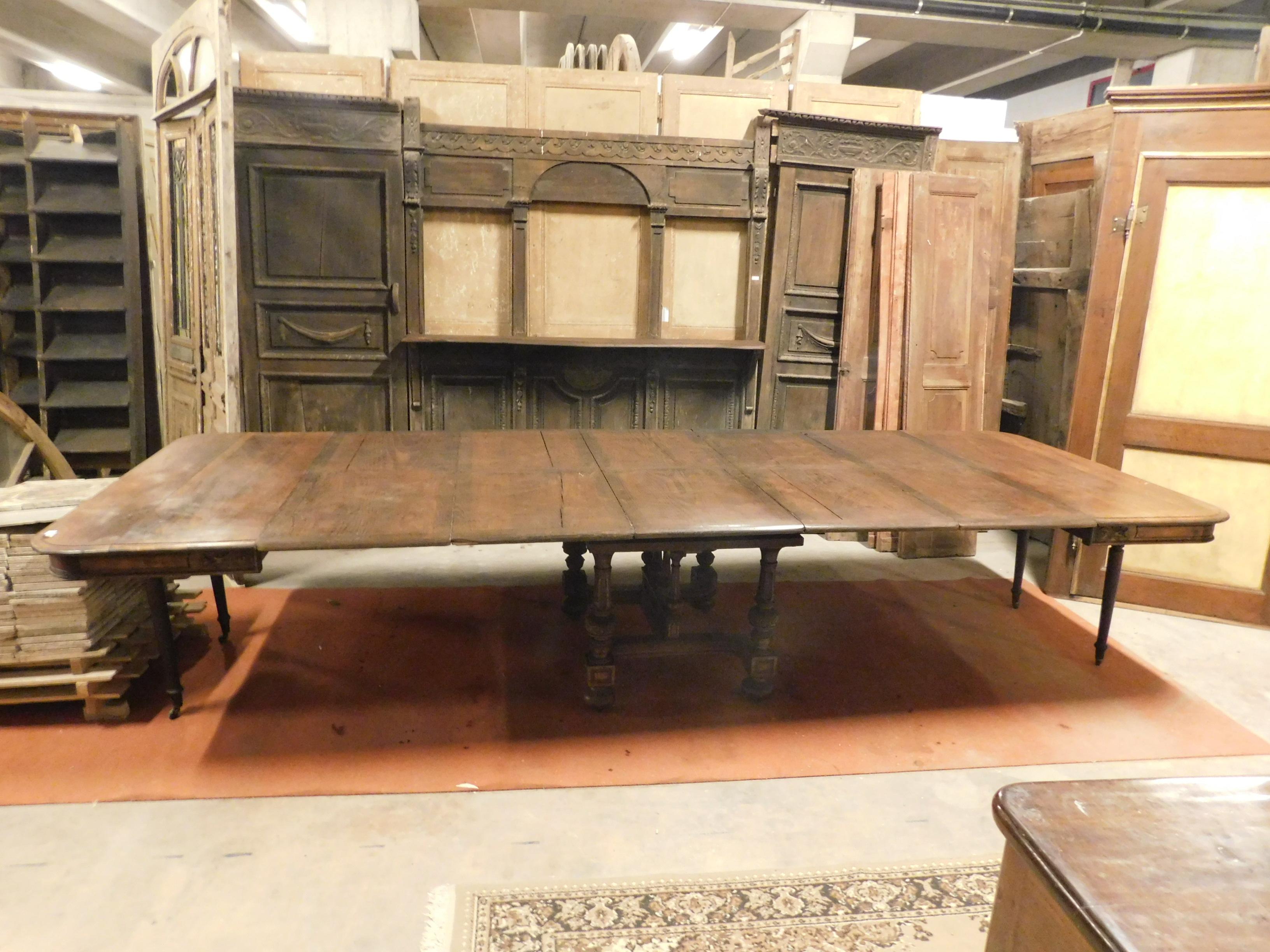 20th century antique extendable table with small wheels, flowered friezes and intermediate planks. Maximum size 368 cm.