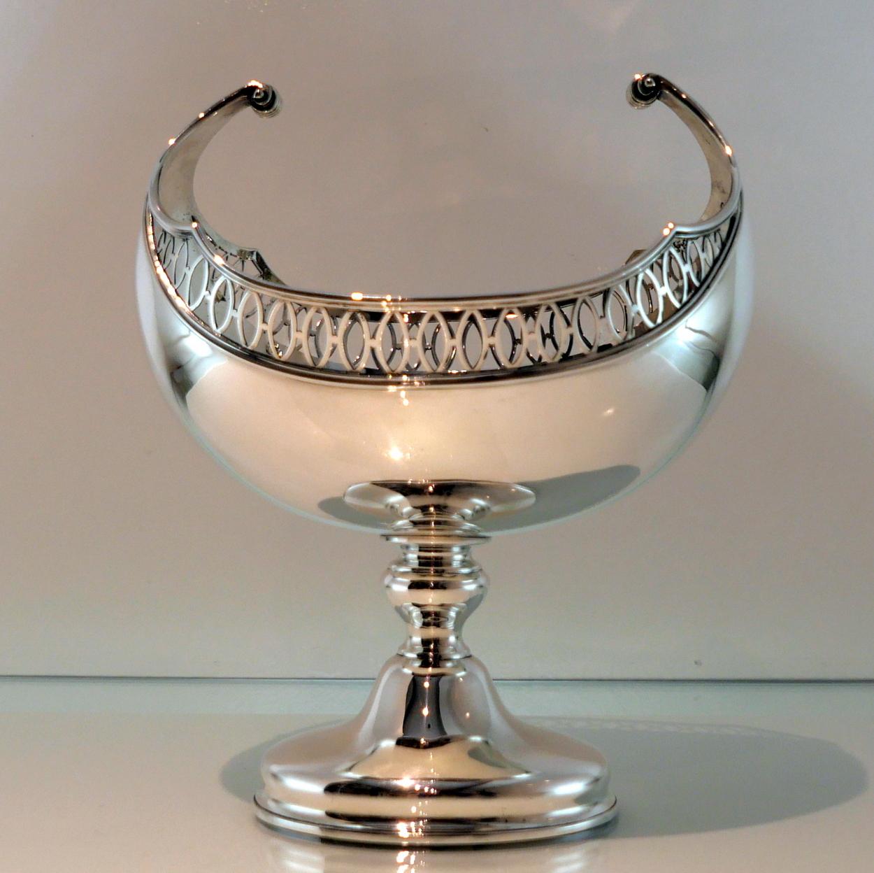 A large beautiful early 20th century silver “boat shaped” sterling silver dish standing on a raised circular pedestal foot. The upper bowl has elegant oval piercing for highlights and stunning “floating handles” for supreme craftsmanship.

