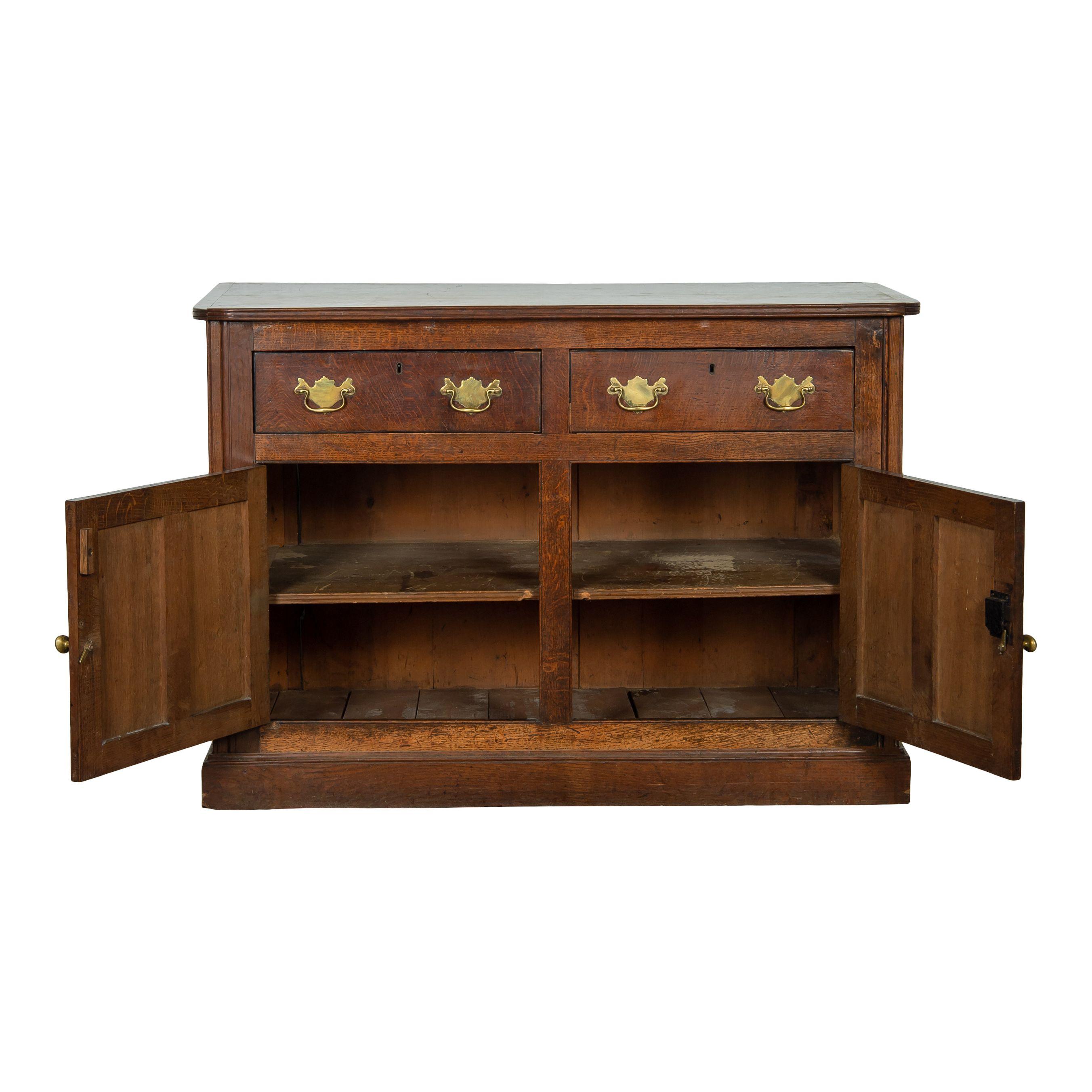 A vintage Georgian wood sideboard with drawers and cabinets. The dark wood gives a classic vintage charm and homey feel. The shape is simple and timeless and the details make it even more beautiful -- the rounded corners of the top and the gold