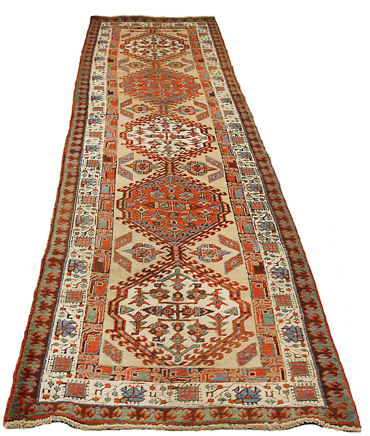 Antique Persian runner rug handwoven from the finest sheep’s wool and colored with all-natural vegetable dyes that are safe for humans and pets. It’s a traditional Azerbaijani design featuring mixed floral and geometric medallion details It