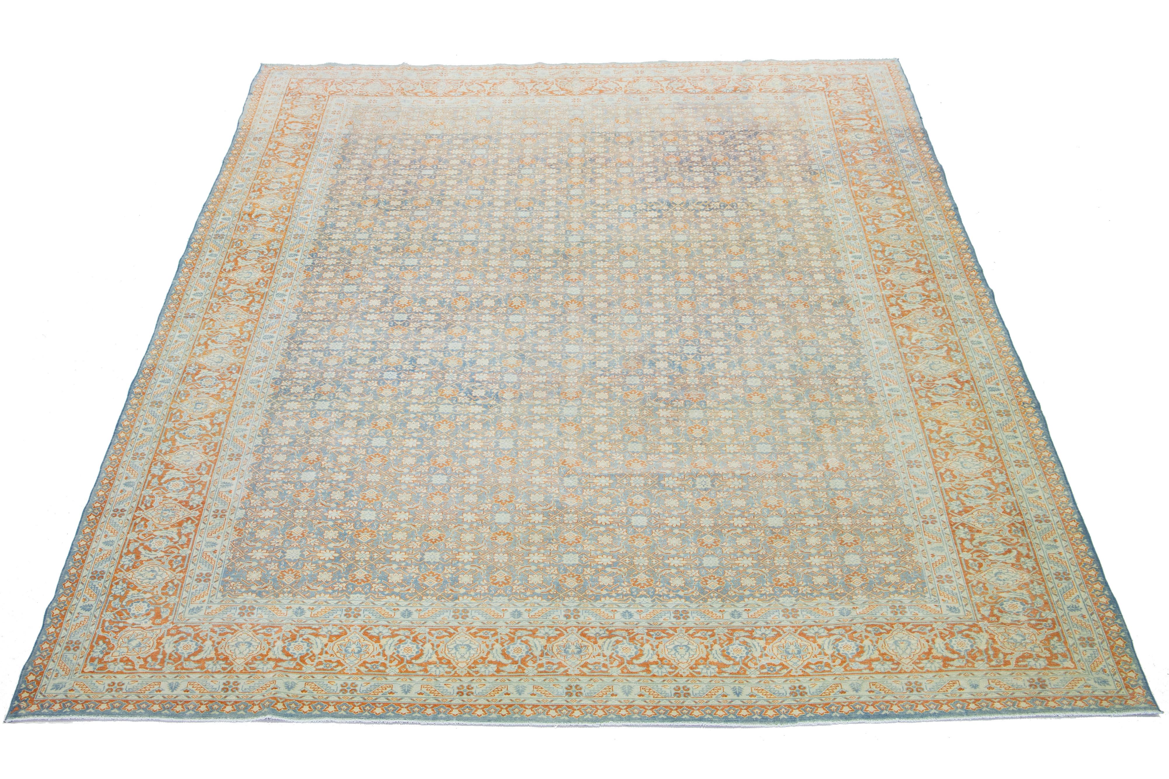 Made of hand-knotted wool, this Persian Malayer rug is an antique piece. It features a beautiful light blue field adorned with orange highlights, all arranged in a timeless classical pattern.

This rug measures 8'11