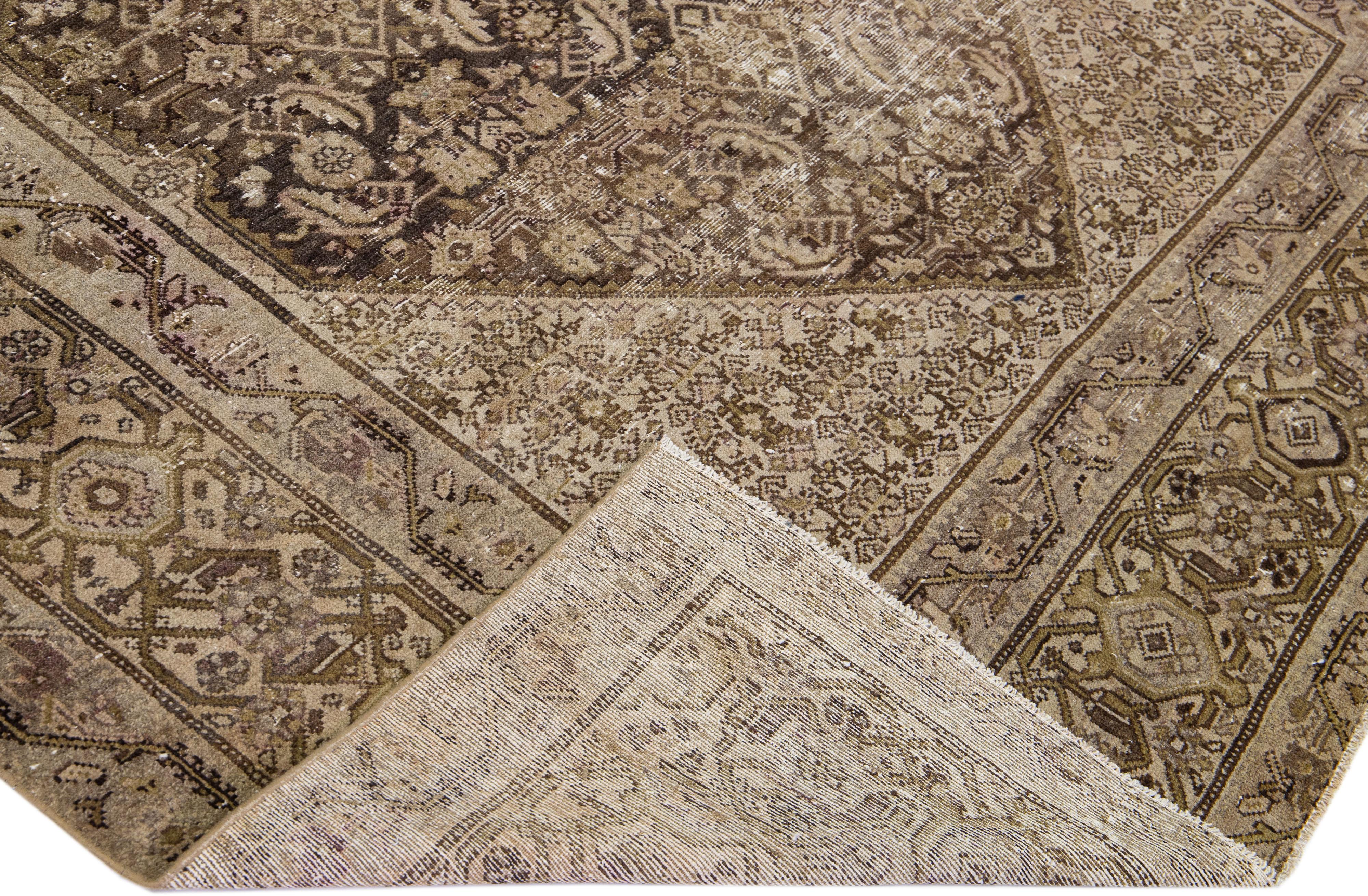 Beautiful antique Malayer hand-knotted wool rug with a brown color field. This Malayer piece has a designed frame with beige accents in a gorgeous all-over floral design.

This rug measures: 7'5