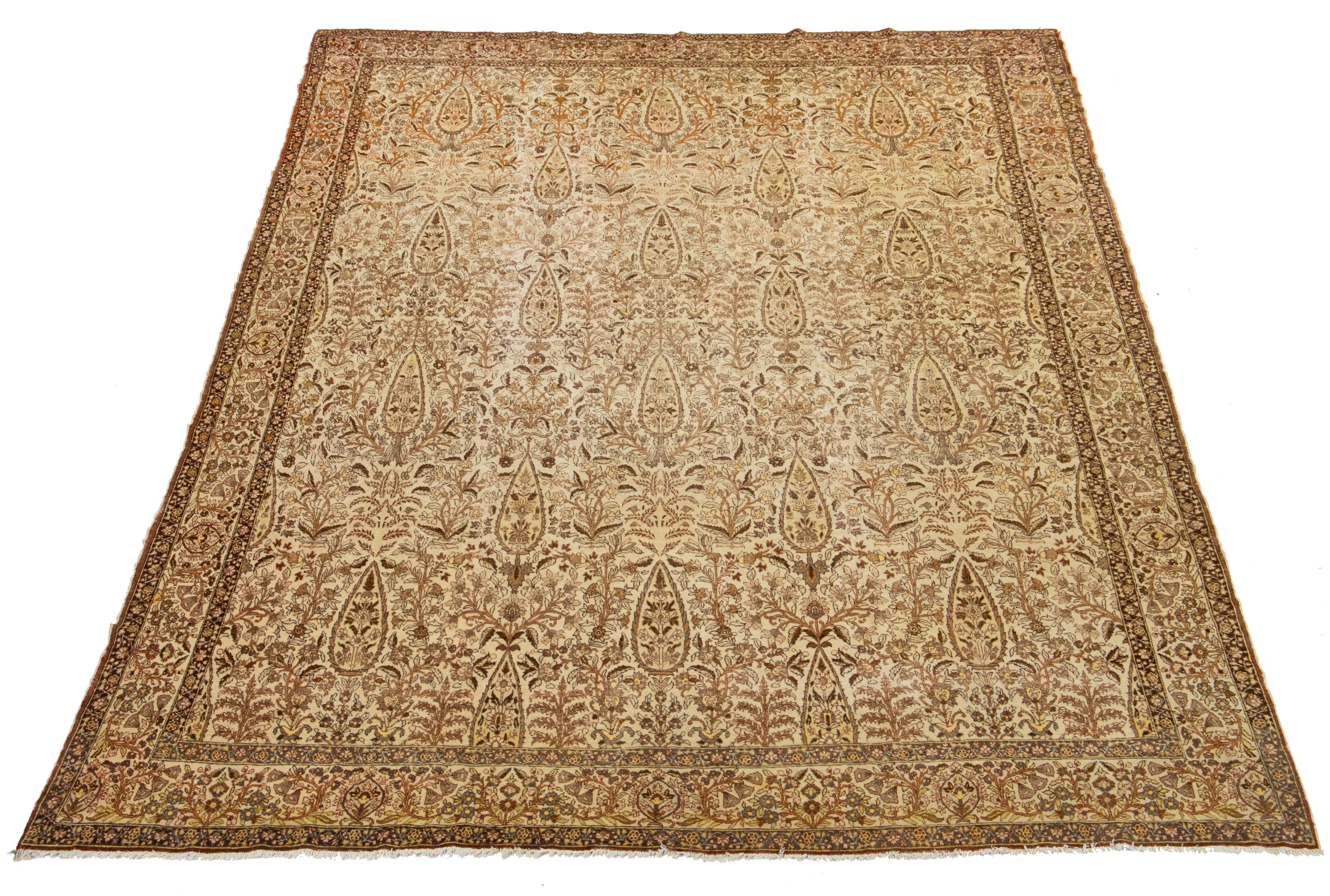 Beautiful antique Persian distressed hand-knotted wool rug with a beige field. This piece has gray, rust, and yellow accents in a gorgeous all-over floral Pattern design.

This rug measures: 9'1' x 13'2