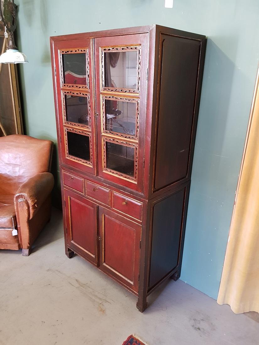 Chinese 2-part cupboard in antique style executed with 2 doors and 3 drawers at the bottom and the upper part has 2 glass doors behind which 2 shelves, these are further in a good condition with light user marks all around (the top lock does not
