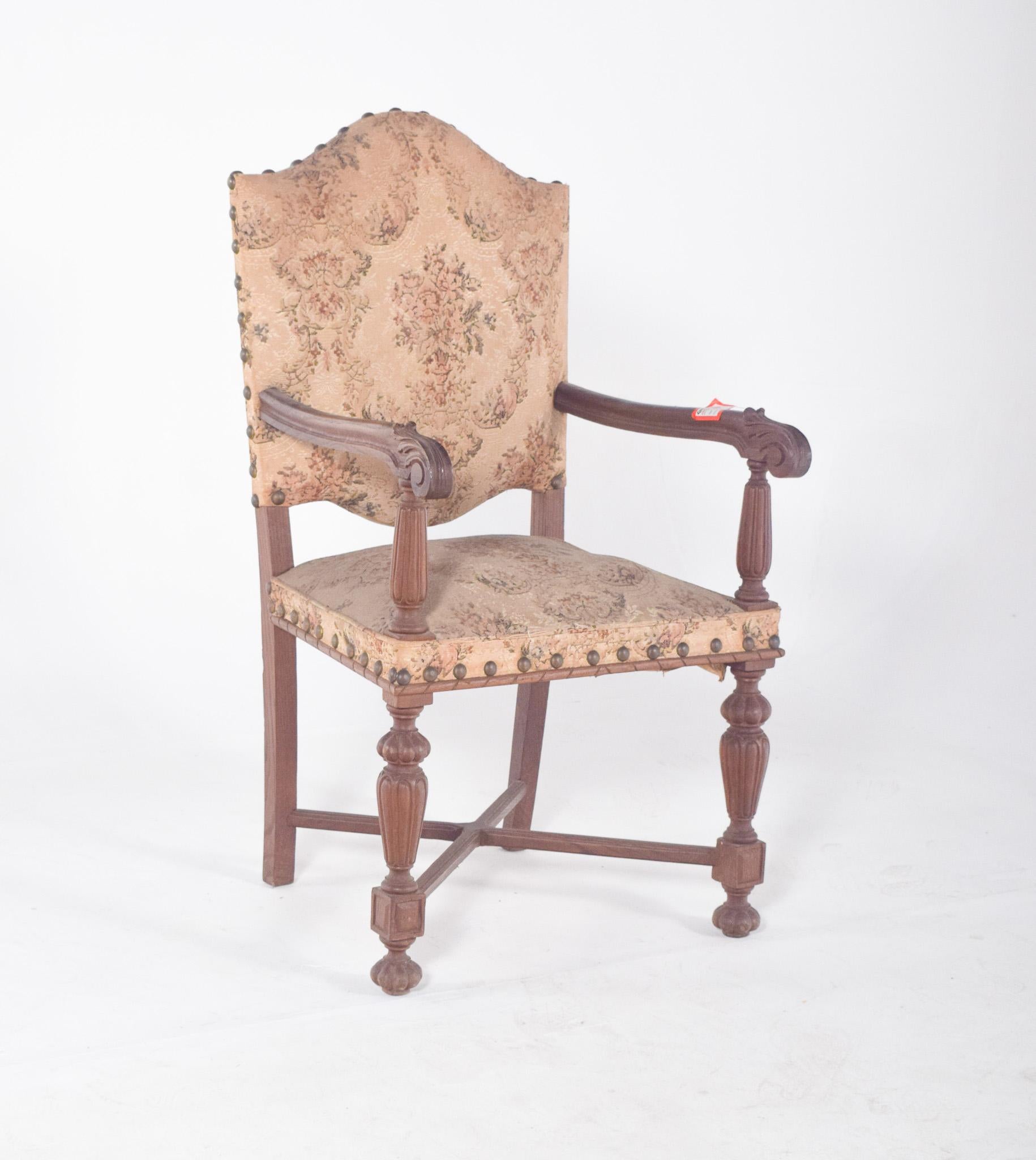 Fauteuil avec dossier et assise tapissés. En bois sculpté, d'inspiration Renaissance, avec un dossier haut et découpé, reflétant une présence et un caractère nobles. L'assise et le dossier sont revêtus d'un tissu damassé beige à motifs floraux, fixé