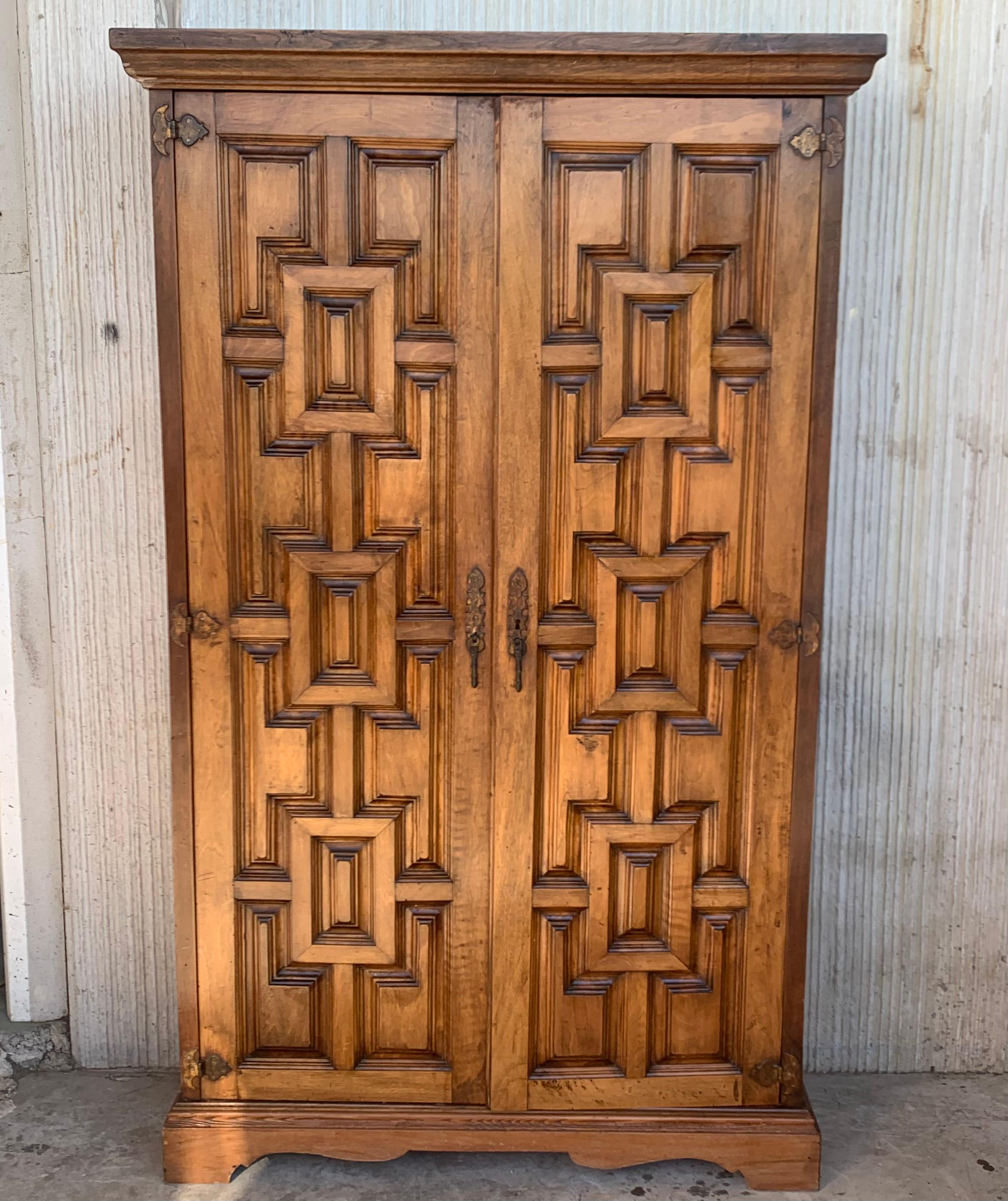 Armoire, cupboard or kitchen cabinet with two doors decorated to the outside with geometric patterns framed by moldings. The legs that protrude below and the cresting and lower molding provide the characteristic curved lines in this period. The