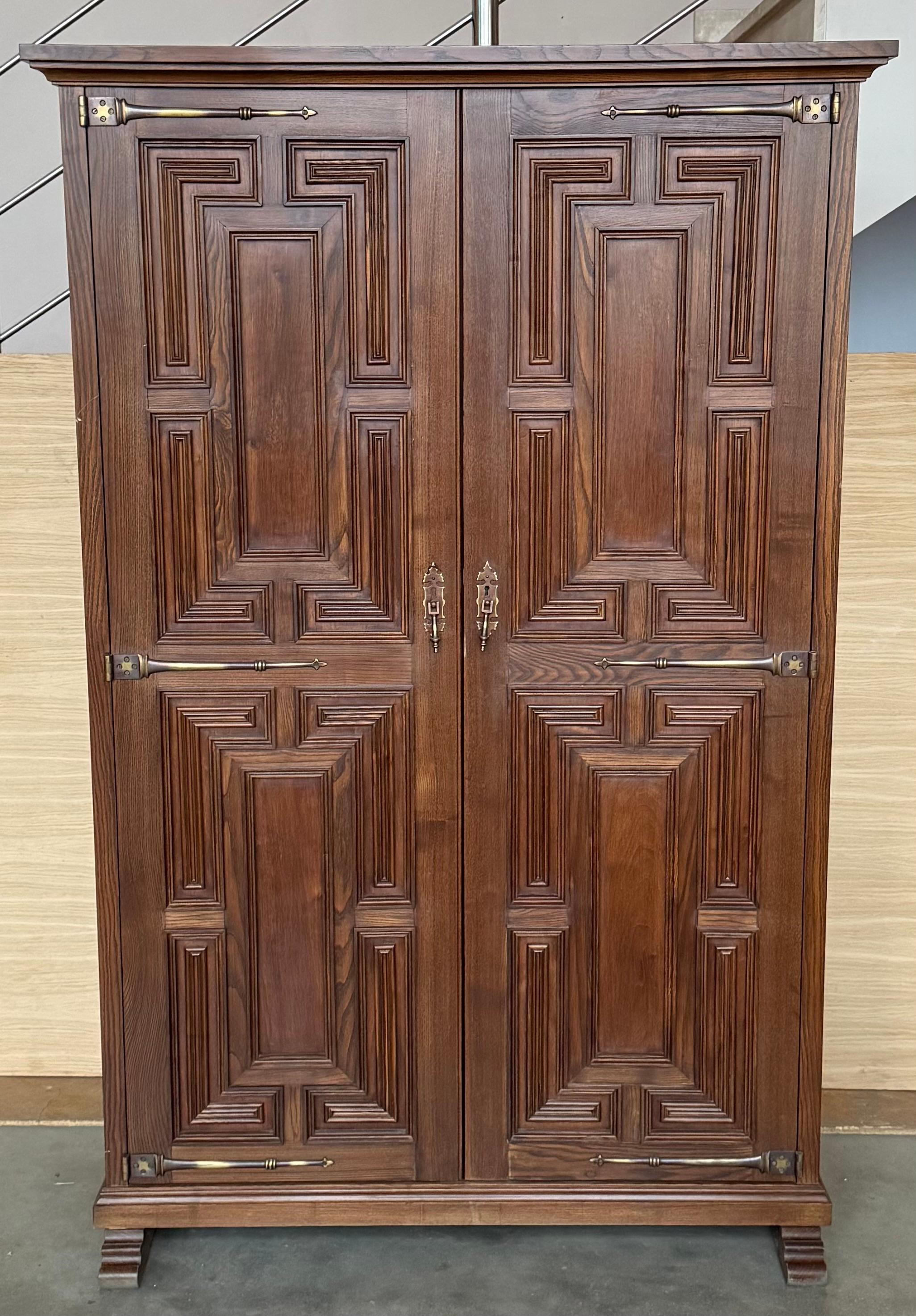 Armoire, cupboard or kitchen cabinet with two doors decorated to the outside with geometric patterns framed by moldings. The legs that protrude below and the cresting and lower molding provide the characteristic curved lines in this period. The