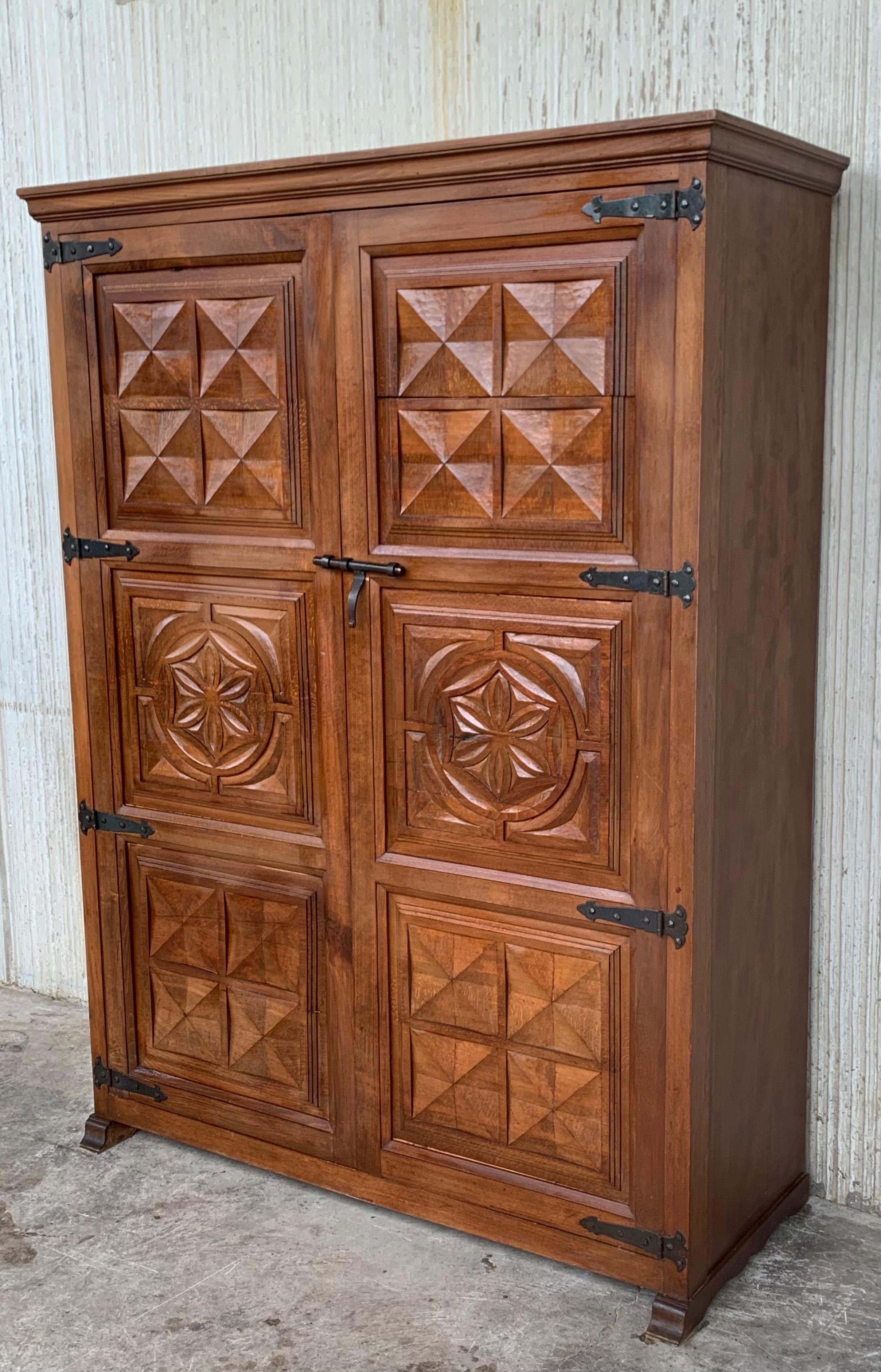 Armoire, cupboard or kitchen cabinet with two doors decorated to the outside with geometric patterns framed by moldings. The legs that protrude below and the cresting and lower molding provide the characteristic curved lines in this period. The