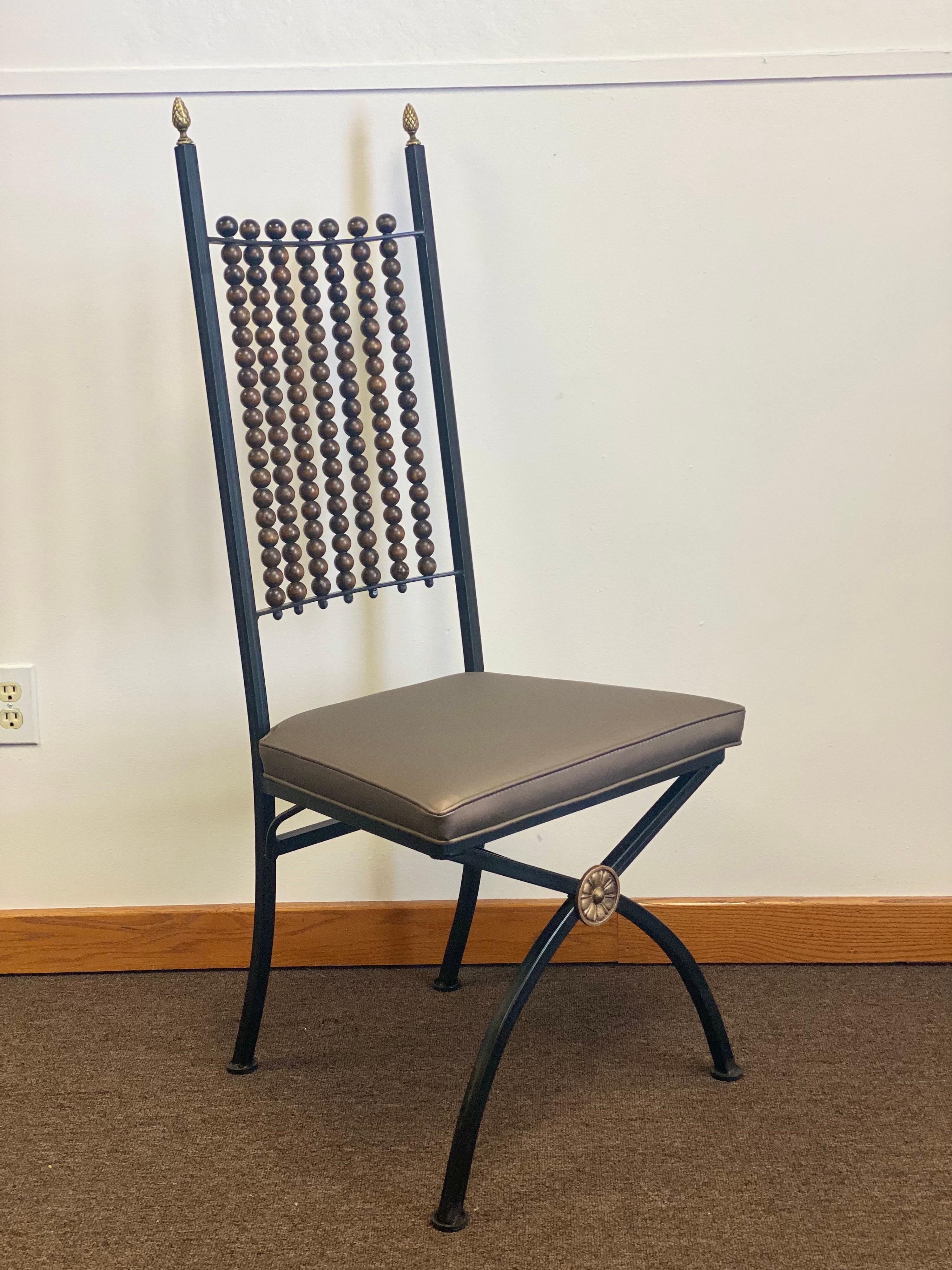 We are very pleased to offer a beautiful set of vintage dining chairs, circa the 1900s. This stunning set has a wonderful sculptural iron frame and showcases seven staggered spires adorned with carved wood spheres, a dimensional look that is out of